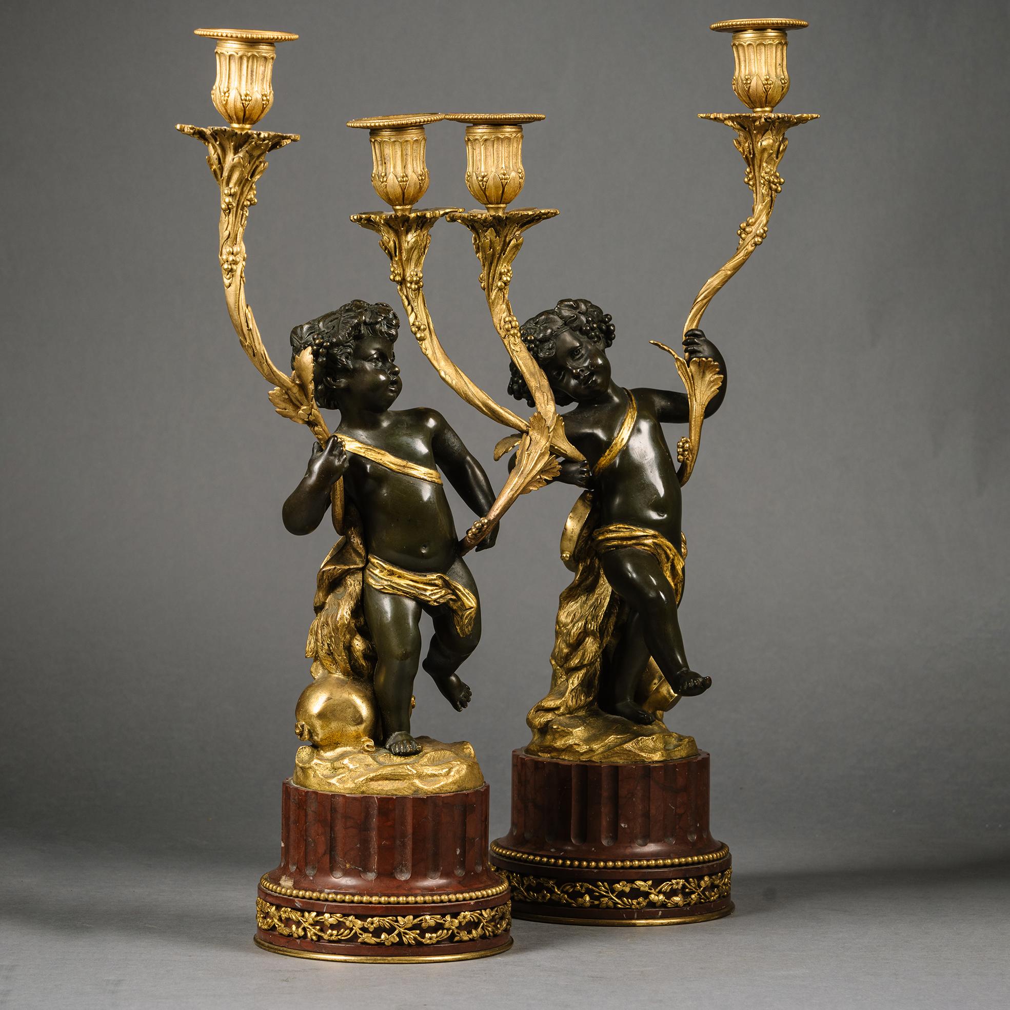 Paire de chandeliers figuratifs en bronze patiné et doré de style Louis XVI. D'après le modèle de Clodion.

Chacun d'entre eux est orné d'un putto dansant, emblème de la musique et du vin. Soutenir les branches de chandelles recouvertes de vigne.