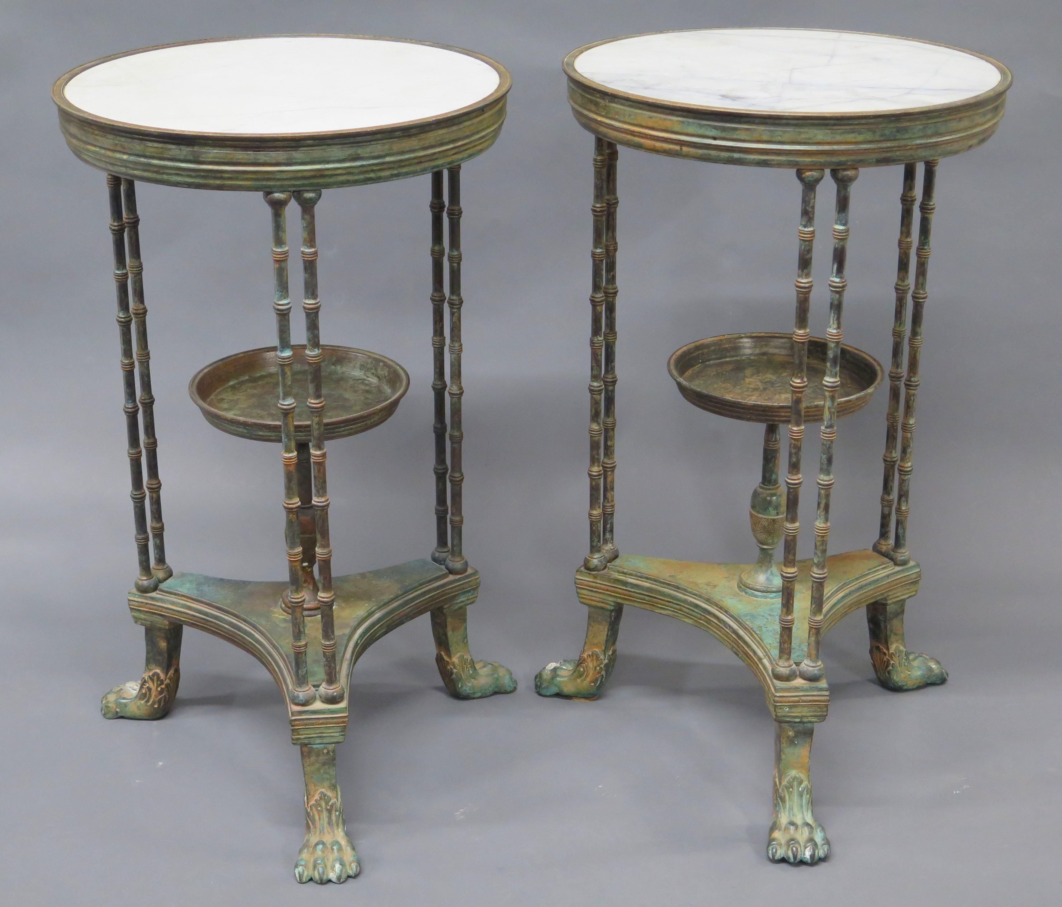 pair of Louis XVI-style patinated bronze gueridons having urn under table top, with carrara (white) marble tops, round table with tripartite base having lion's paw feet, three slender pairs of bamboo form legs support the table top, late 19th /
