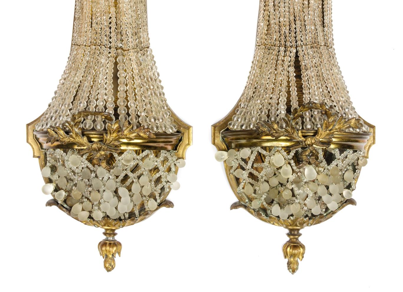 Pair of gilded and chased bronze balloon-shaped sconces with glass bead decorations. The upper part is decorated with ribbon bows and the central part is decorated with laurel branches. Good condition, light wear of gilding, stamp with