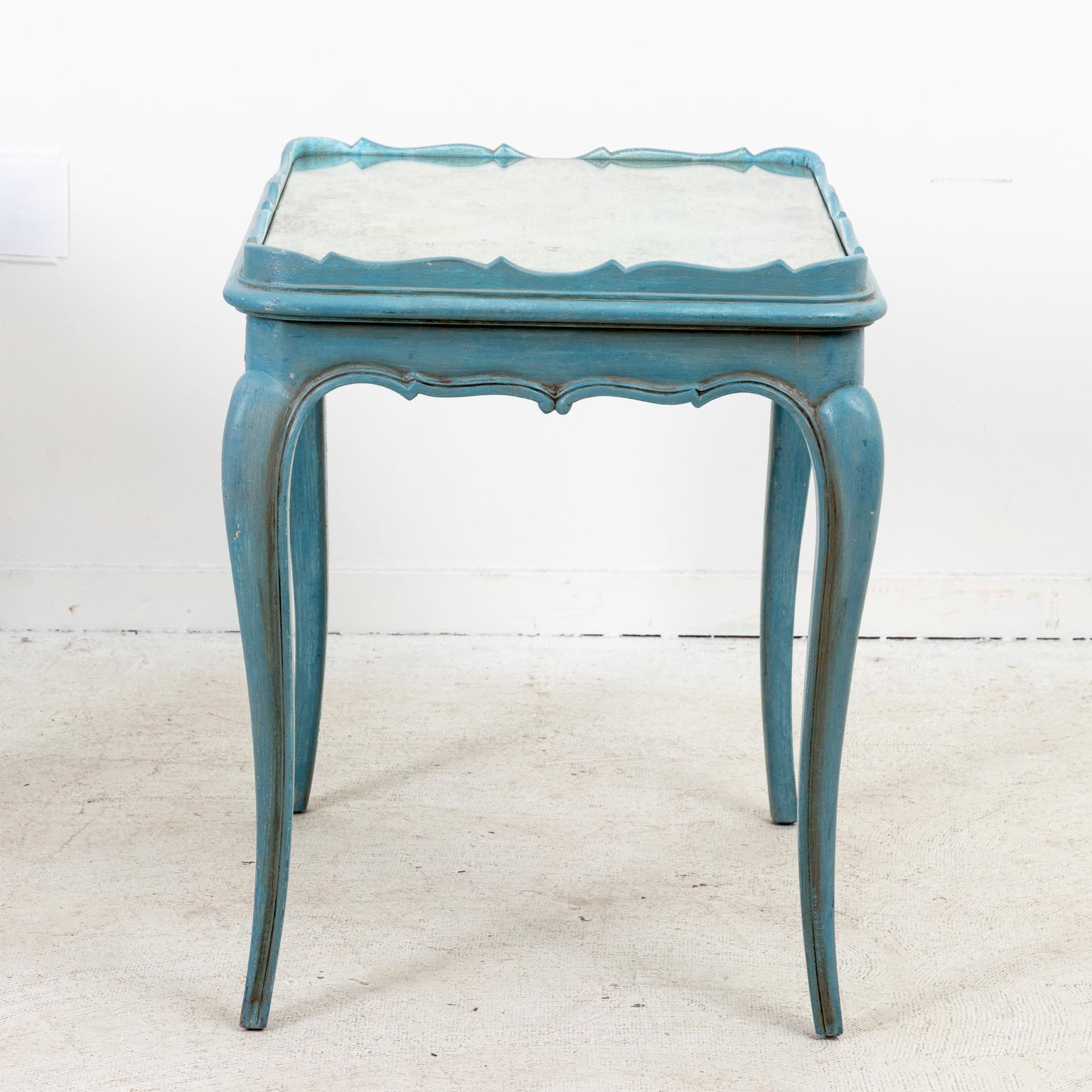 Circa mid-20th century pair of soft blue painted Louis XVI style side tables with carved scallop shells on the skirt and mirrored table tops with rounded corners and curved gallery . The tables also feature cabriole turned legs. Please note of wear