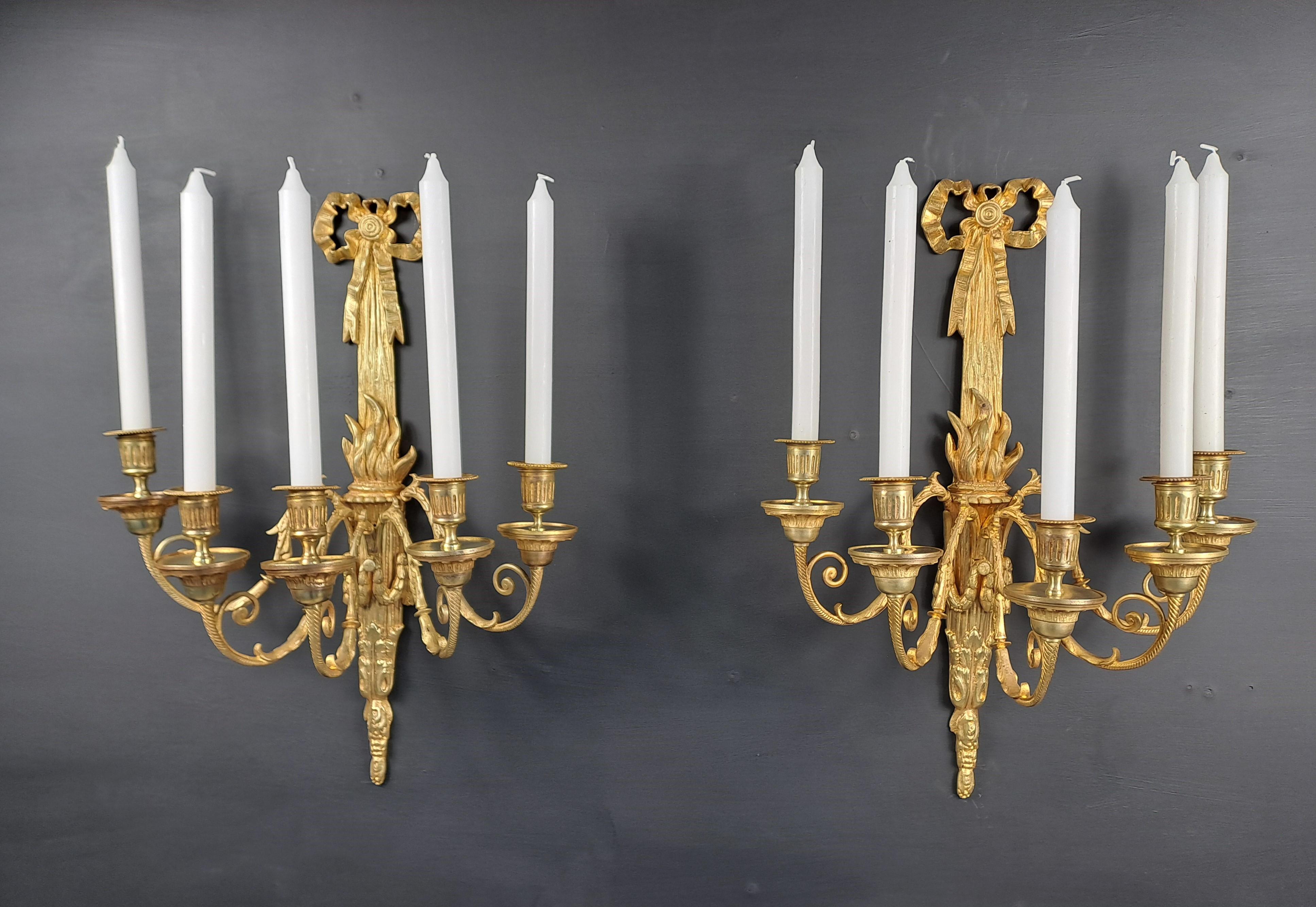 Large pair of Louis XVI style wall lights in chiseled and gilded bronze, decorated with a firepot and garland and presenting five arms of lights.

Work from the Napoleon III period, stamped VB and numbered on the reverse.

Good condition, not
