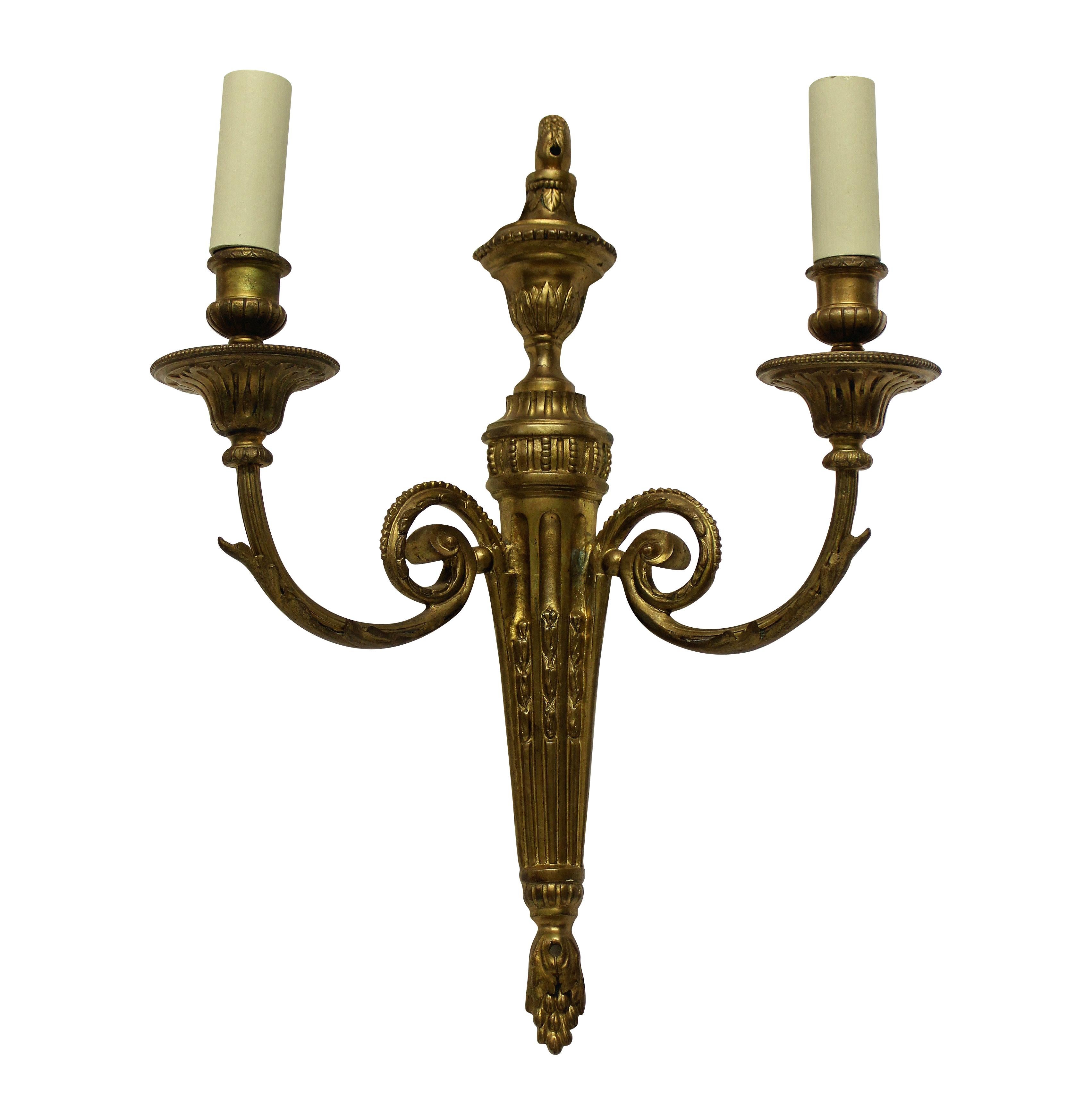 A pair of French Louis XVI style twin branch, gilt bronze wall sconces.