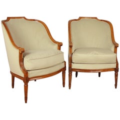 Pareja de bergeres o sillones Luis XVI de nogal, franceses, hacia 1780