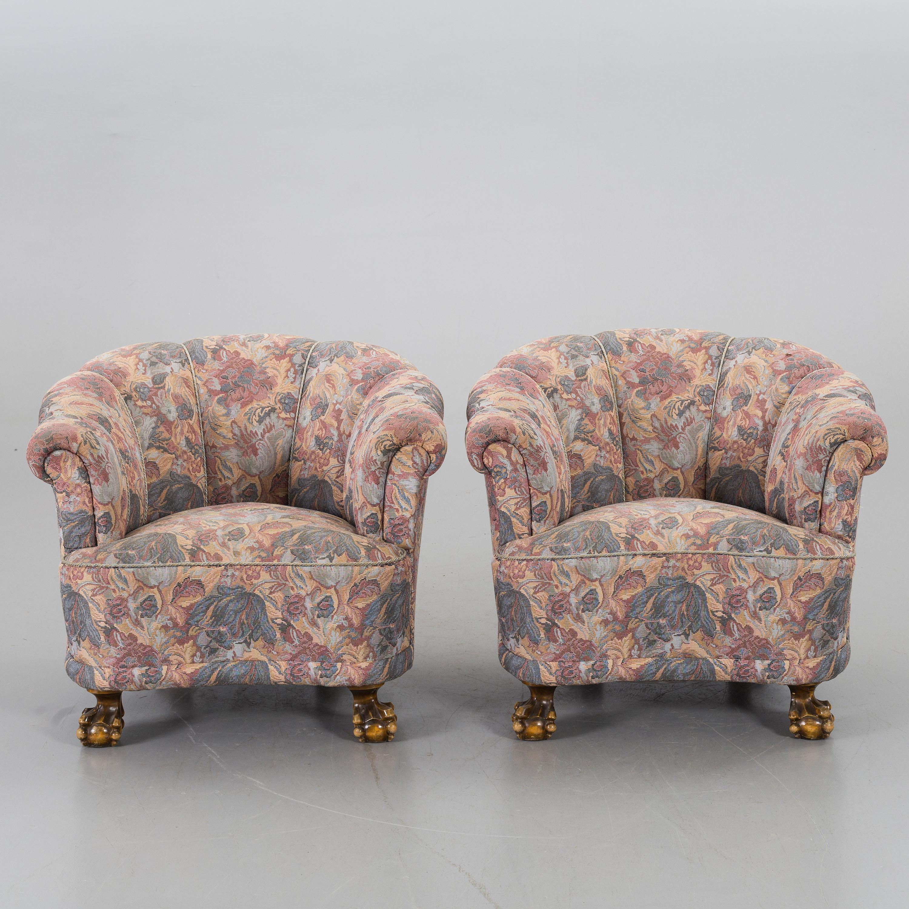 Pair of Scandinavian Modern lounge chairs with channelled backs, deep and comfortable from 1930s with
very expressive paw feet, hand carved in beech in original rose and pale blue upholstery fabric.