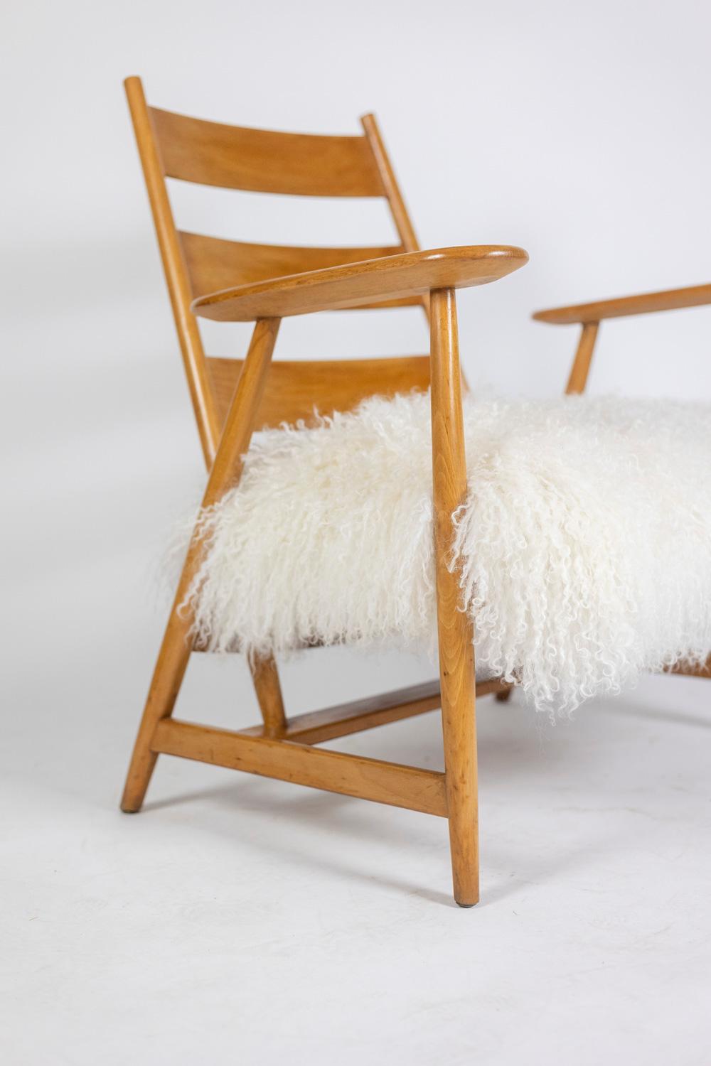 Paire de fauteuils « lounge » en hêtre blond. Dossier de forme incurvée, piètement de forme compas avec sa barre d’entretoise. Accotoirs larges. Assise en peau de chèvre tibétaine.

Travail français réalisé dans les années 1950.