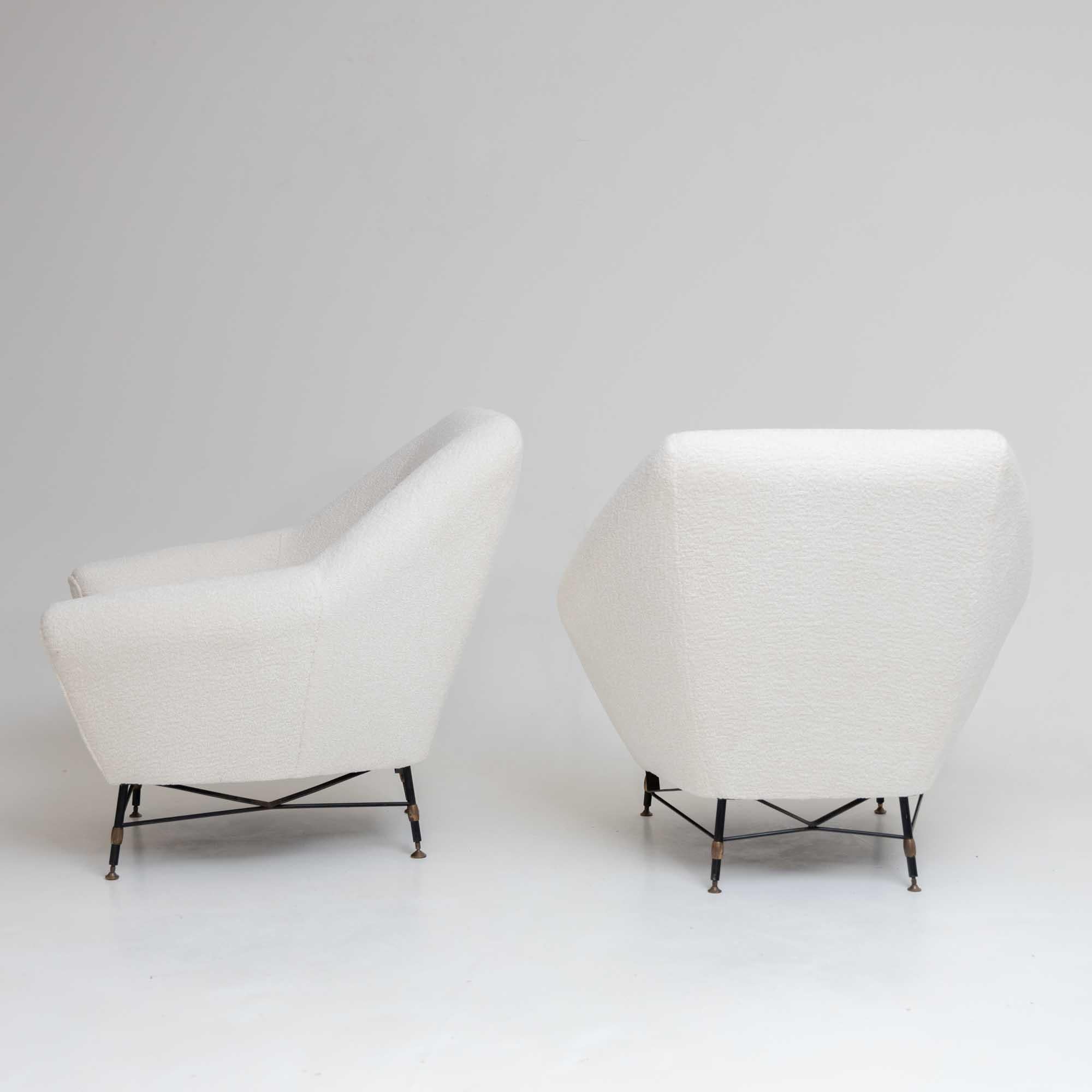 This duo of generously cushioned lounge chairs features elegantly shaped iron frames, offering a perfect blend of comfort and style. Recently reupholstered with a chic white bouclé fabric, these chairs bring a touch of modern sophistication to any