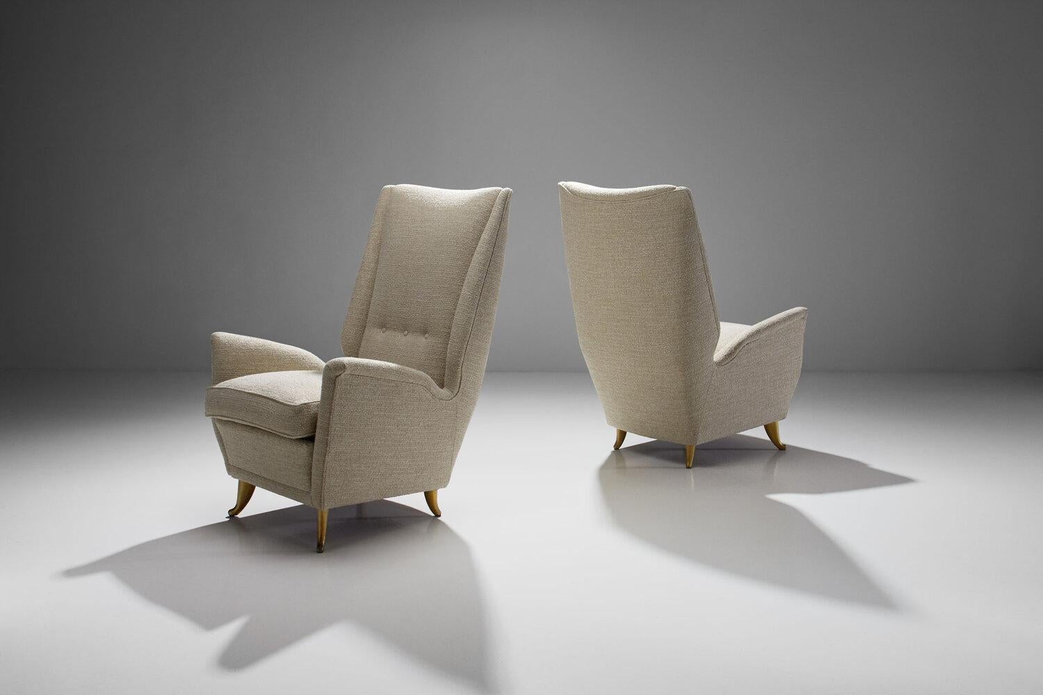 Pair of lounge chairs attributed to Gio Ponti for ISA Bergamo, Italy, 1950s

A pair of elegant high back chairs gracefully resting on four brass-colored metal curved feet. The strong lines and proportions of the chairs are perfectly balanced with