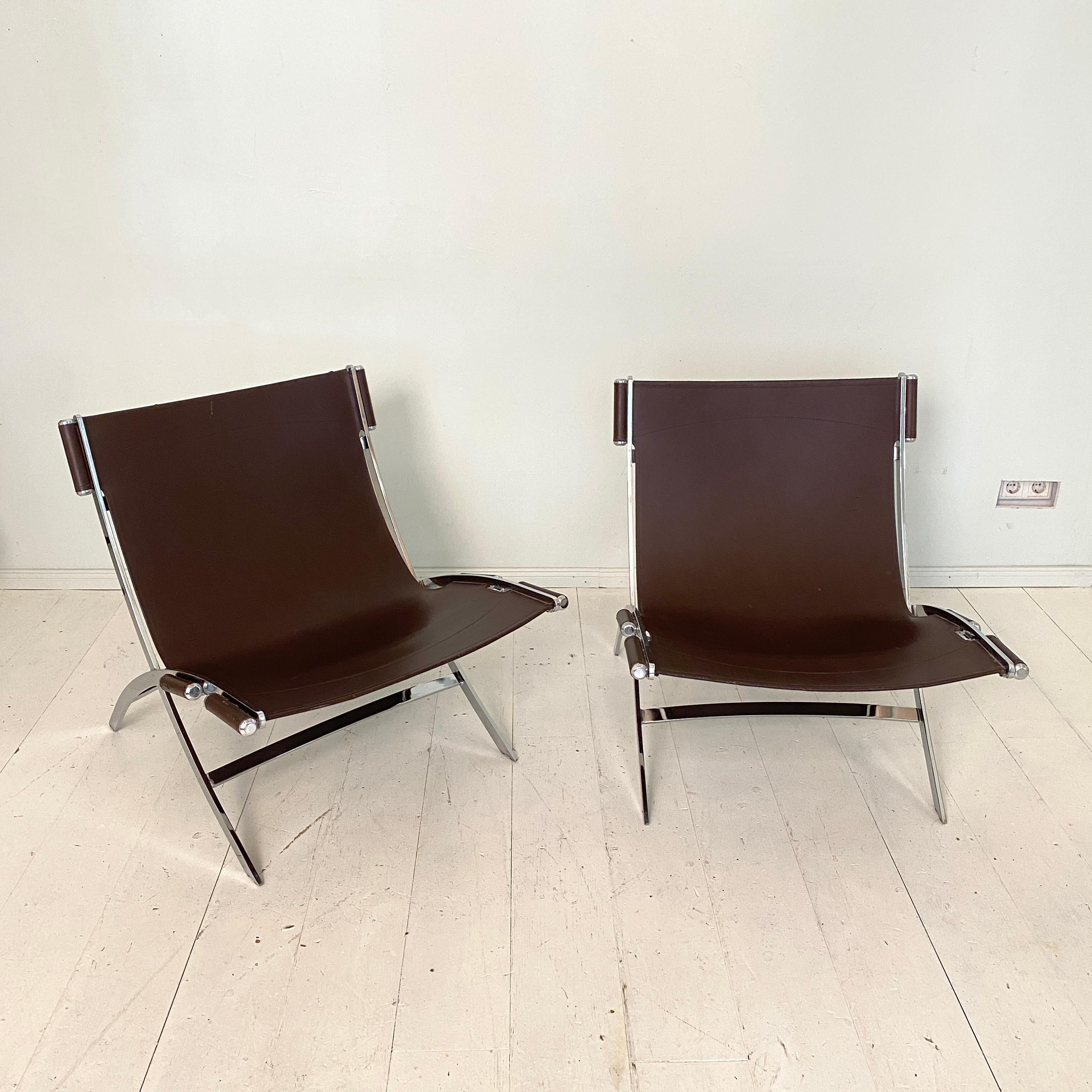 Pair of mid century lounge chairs 'Scissor' by Antonio Citterio in Chrome and Leather for Flexform, made around 1978.
The thick brown leather is neatly stretched within the frame, and held in place by six chrome cylinder shaped capsules.

A