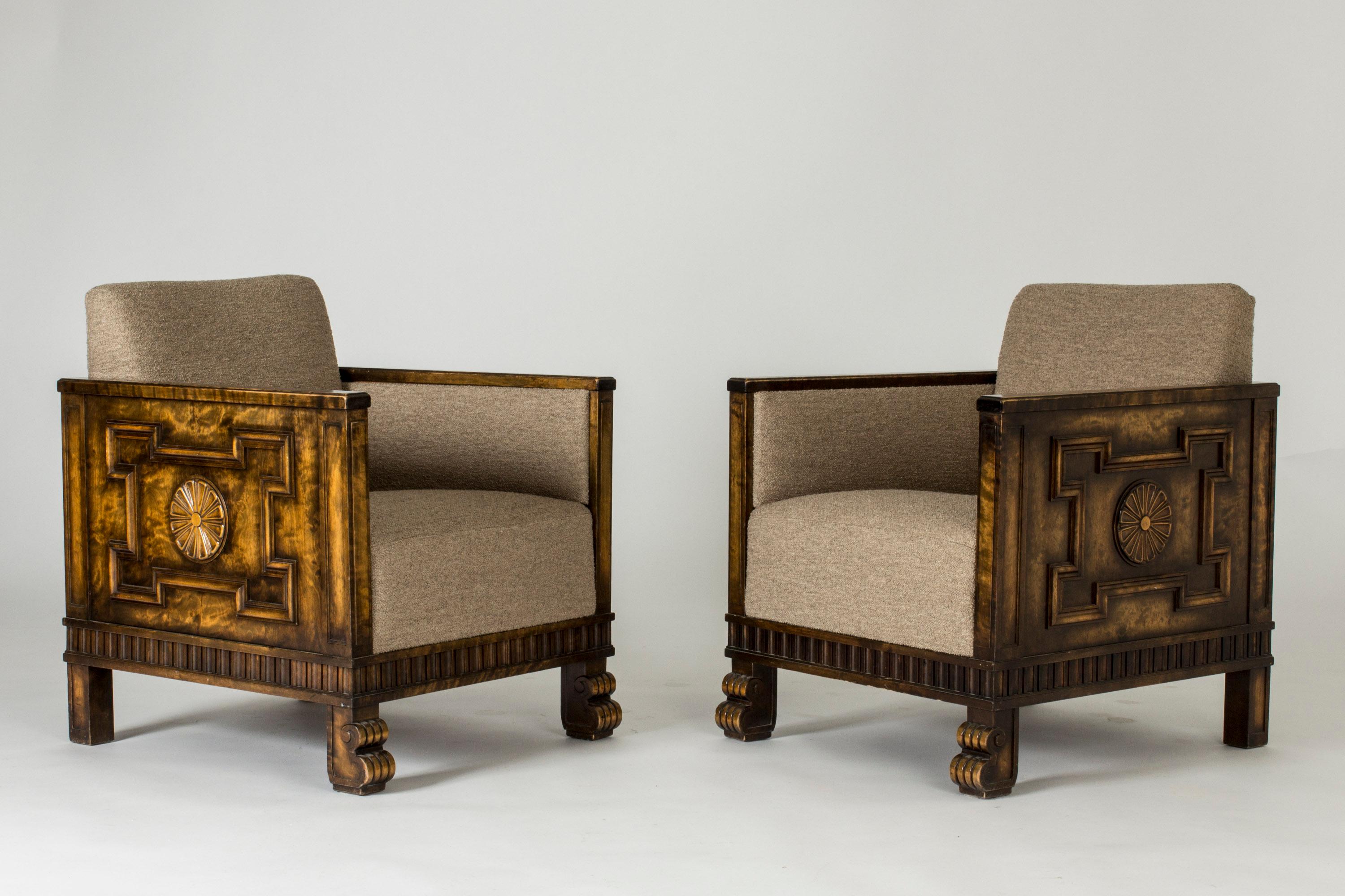 Pair of imposing lounge chairs by Axel Einar Hjorth, in a cubical design with rich ornamental decor. Made from dark stained birch, with bouclé upholstery. Striking combination of modernist lines and baroque influences.