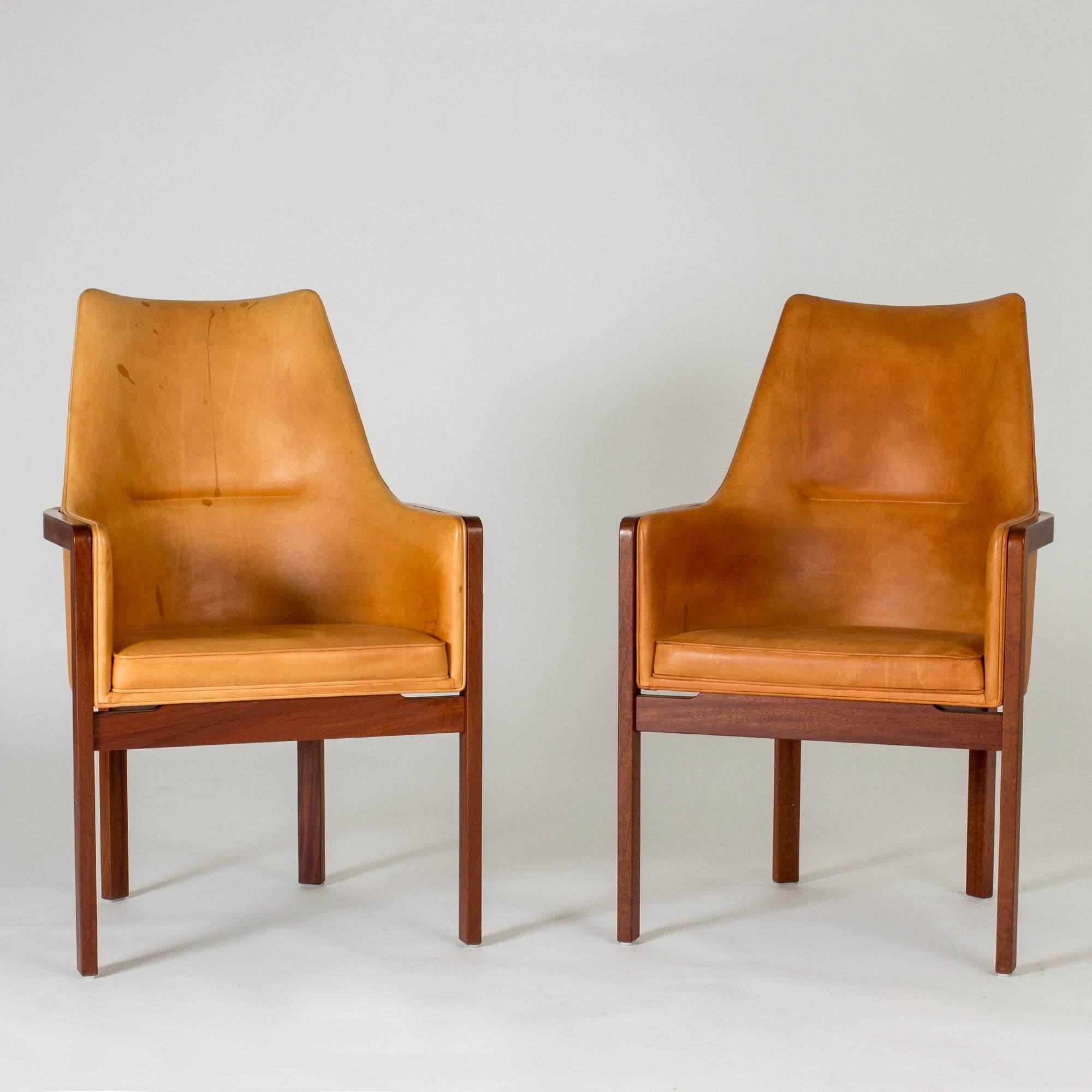Pair of elegant armchairs by Bernt Petersen, with rosewood frames and comfortable natural leather seats and backs. Smooth lines with nicely contrasting materials. Leather in very good condition, but with some patina.