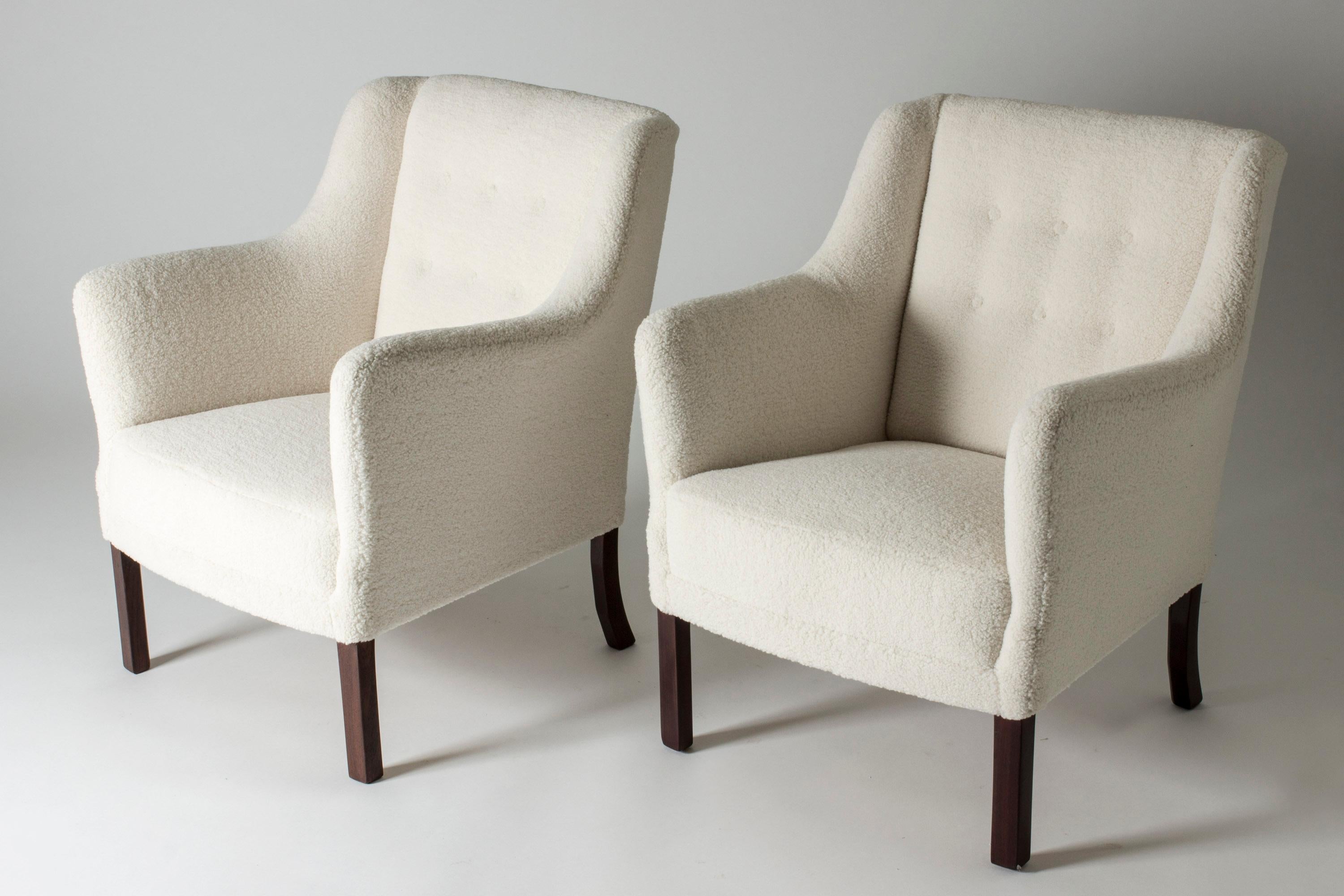 Pair of elegant lounge chairs by Einar Larsen. Contemporary look, upholstered with white bouclé fabric. Designed in 1945.