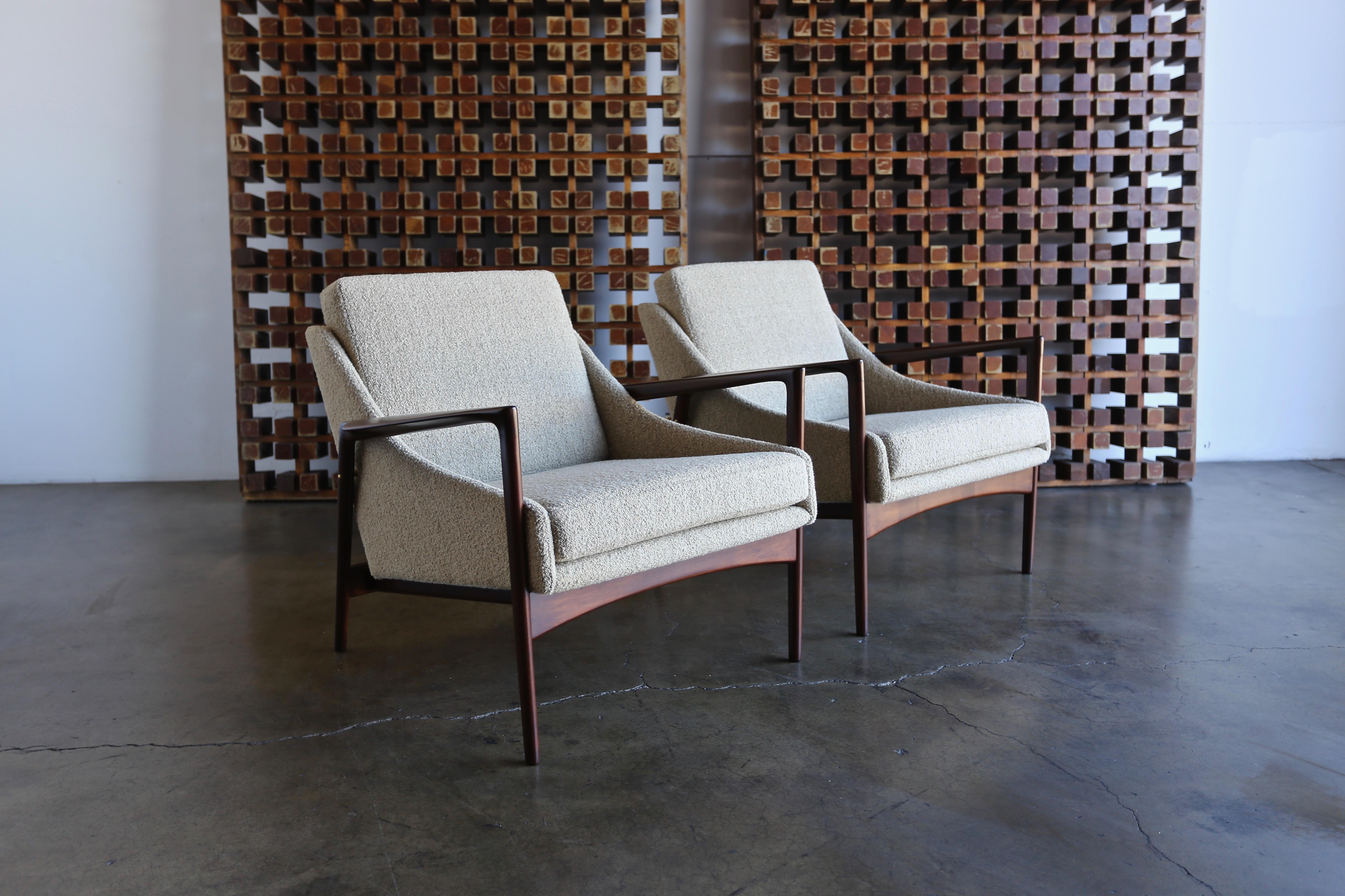 A pair of lounge chairs by Ib Kofod Larsen, circa 1960. This pair has been professionally restored.