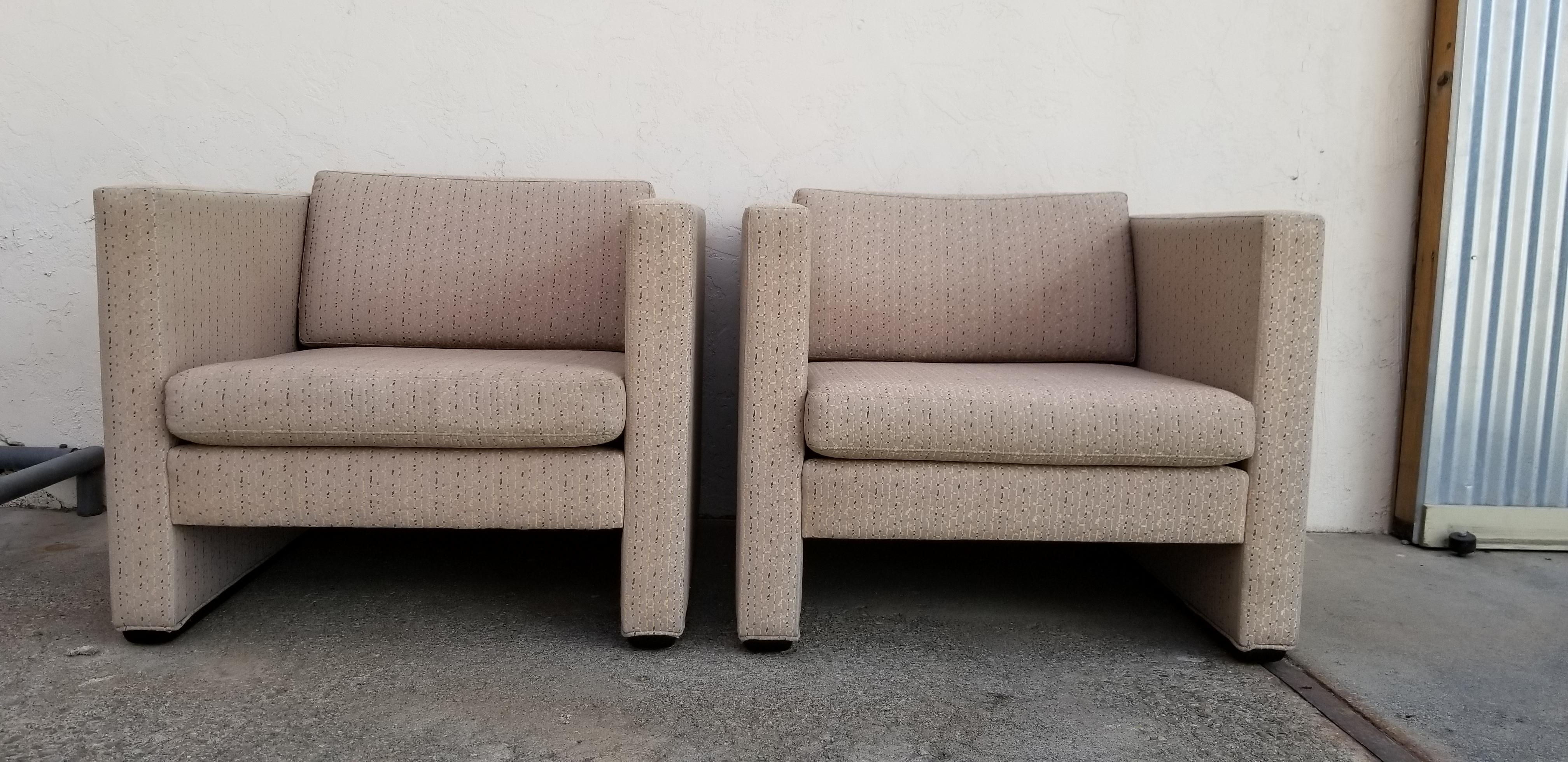 A pair of 1980s upholstered lounge chairs by Jack Cartwright Inc. Square, cubical design with wood base. Reversible cushions. Original fabric in excellent condition. Retaining label, dated 1989.