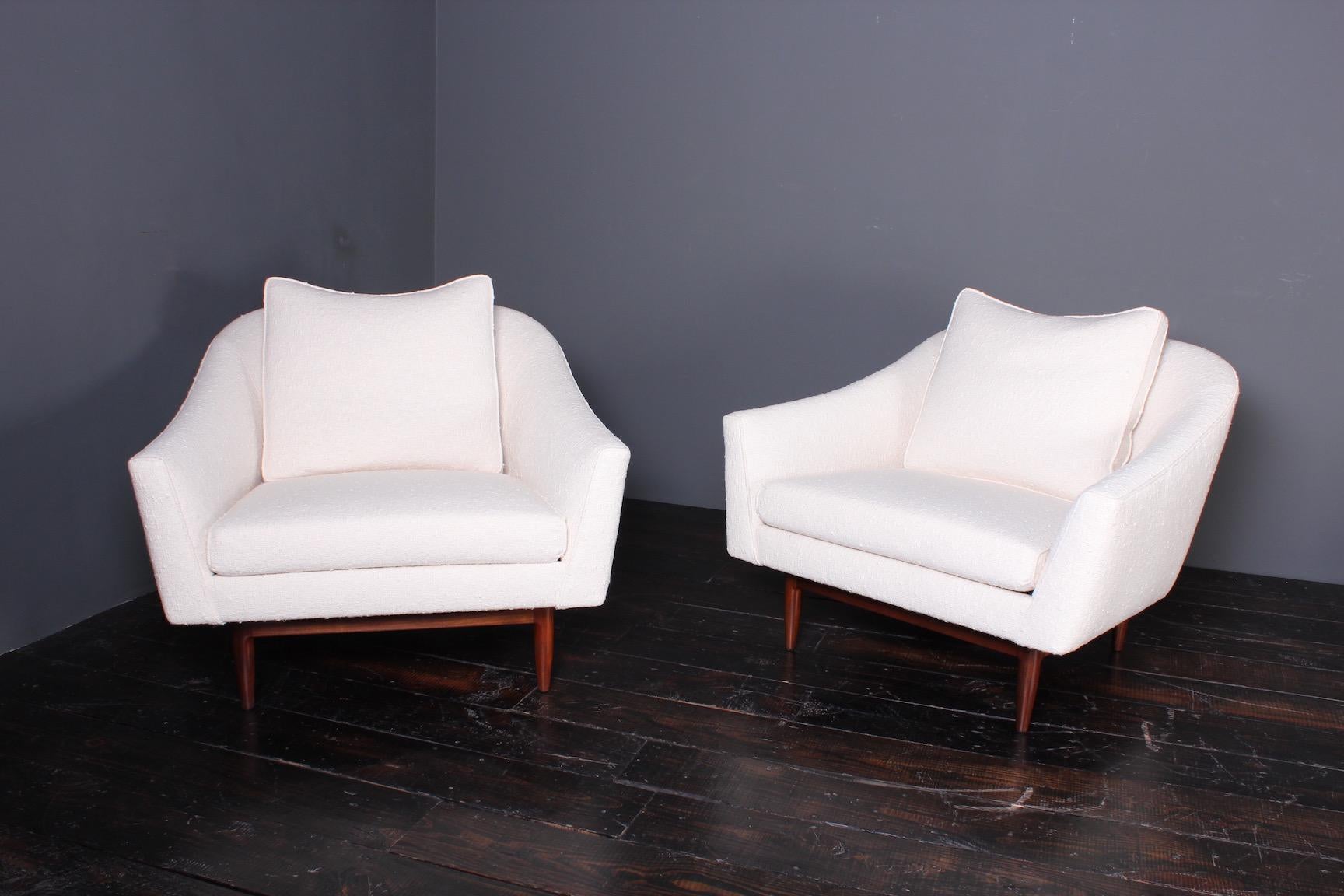 A pair of large scale lounge chairs with walnut bases. Designed by Jens Risom. Fully restored and upholstered in Holly Hunt Cobblestone fabric.