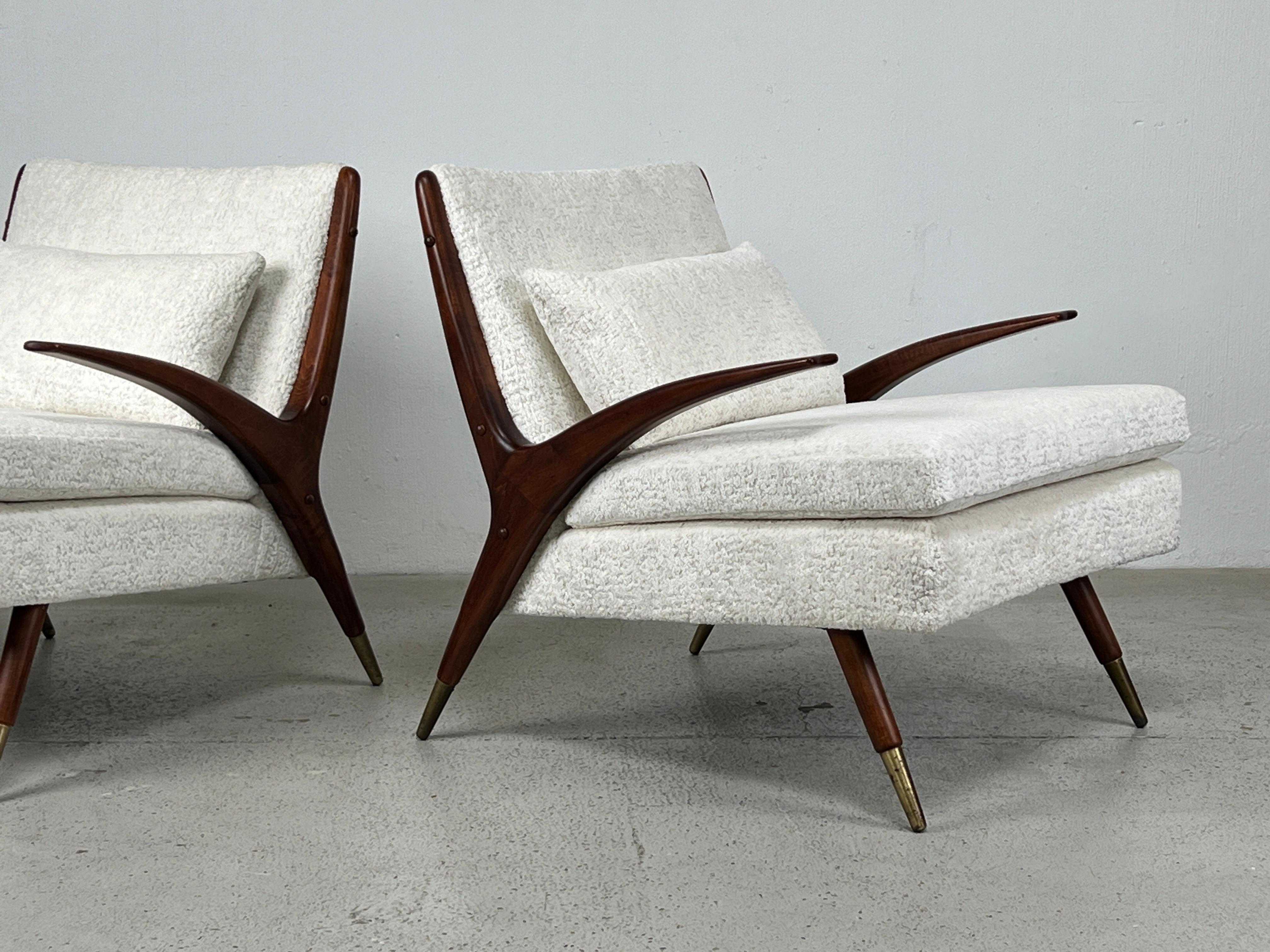 A pair of walnut lounge chairs with brass sabots by Karpen of California, 1950's. Restored and reupholstered in Holly Hunt fabric. 