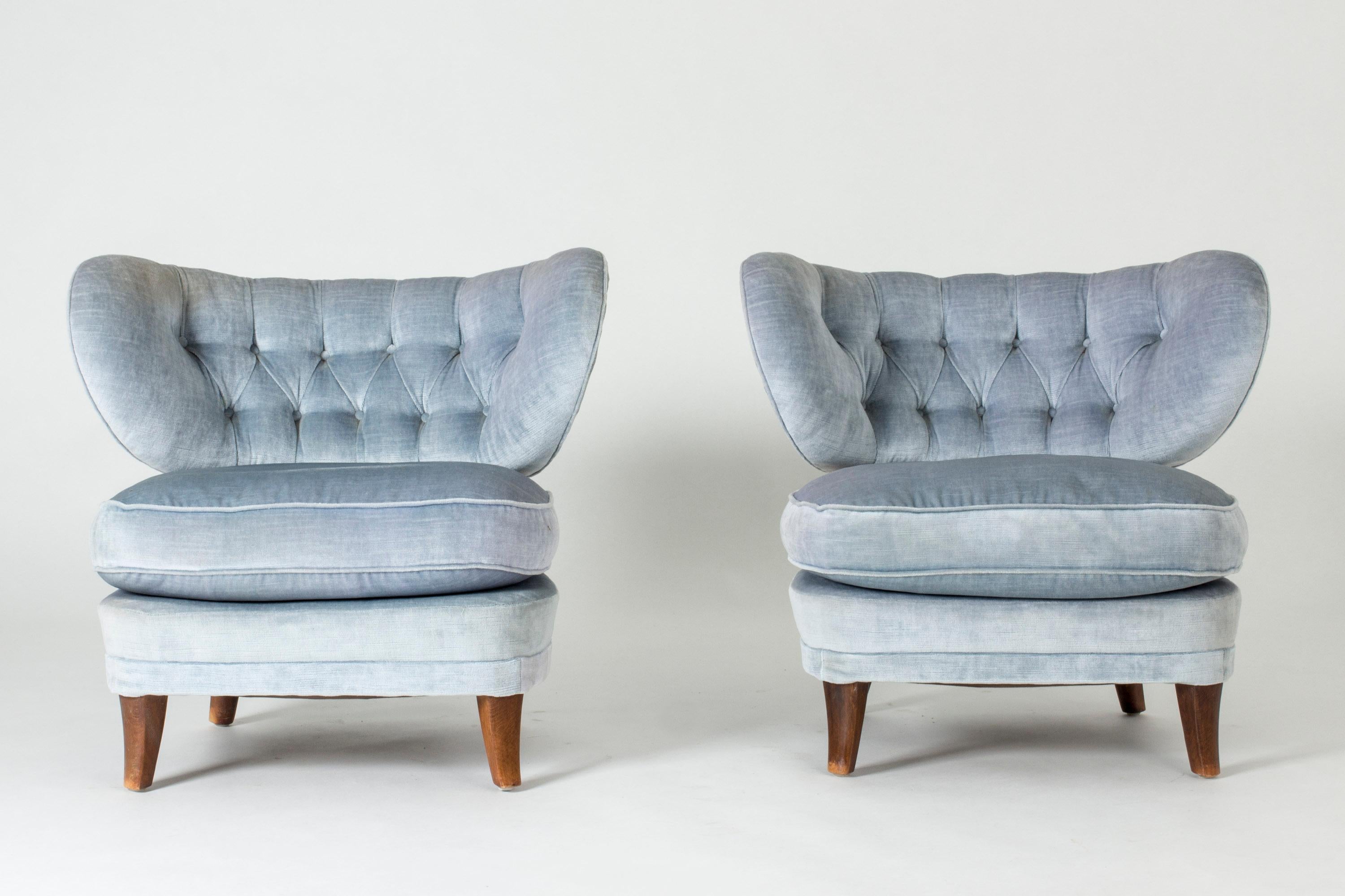 Pair of beautiful lounge chairs by Otto Schulz, upholstered with sky blue velvet and decorated with buttons in the back. Loose cushions. Generous design, great comfort.
 