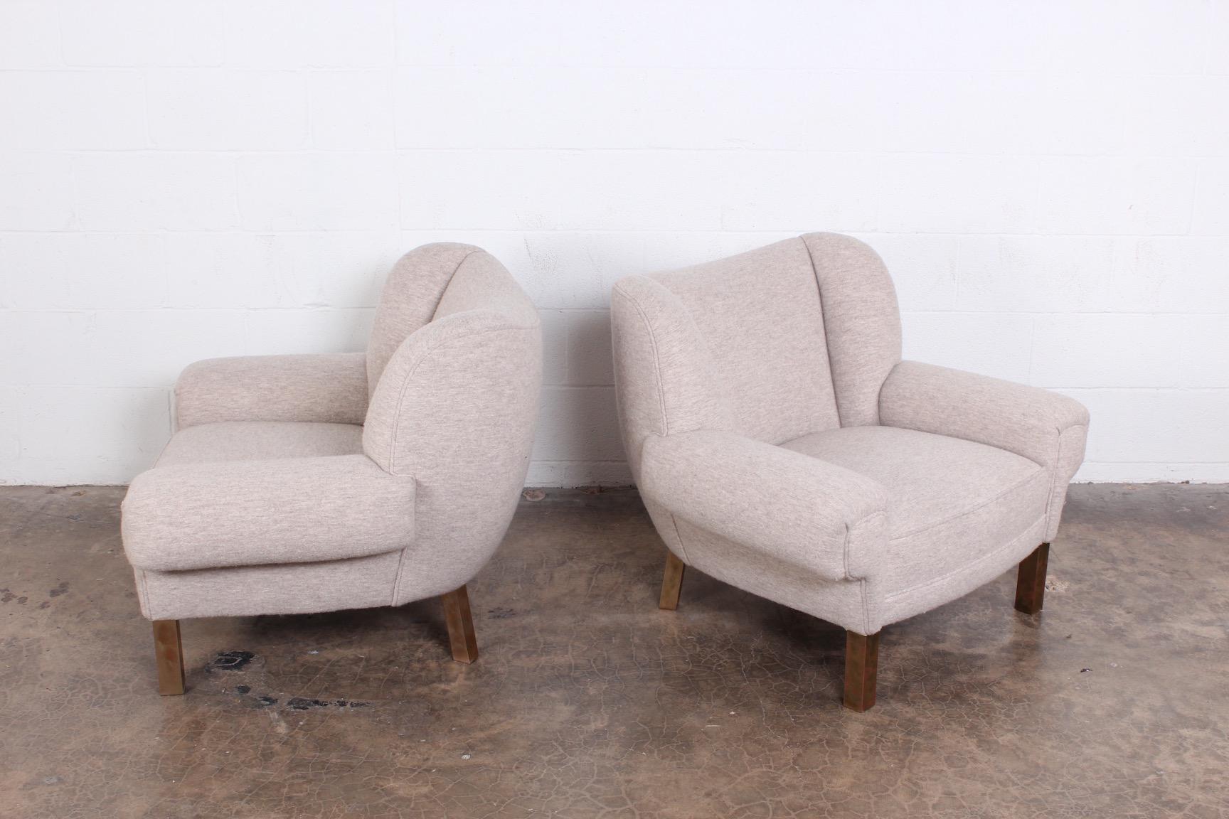A rare pair of lounge chairs designed by Paul Laszlo for Herman Miller. Newer upholstery with original patinated brass legs.