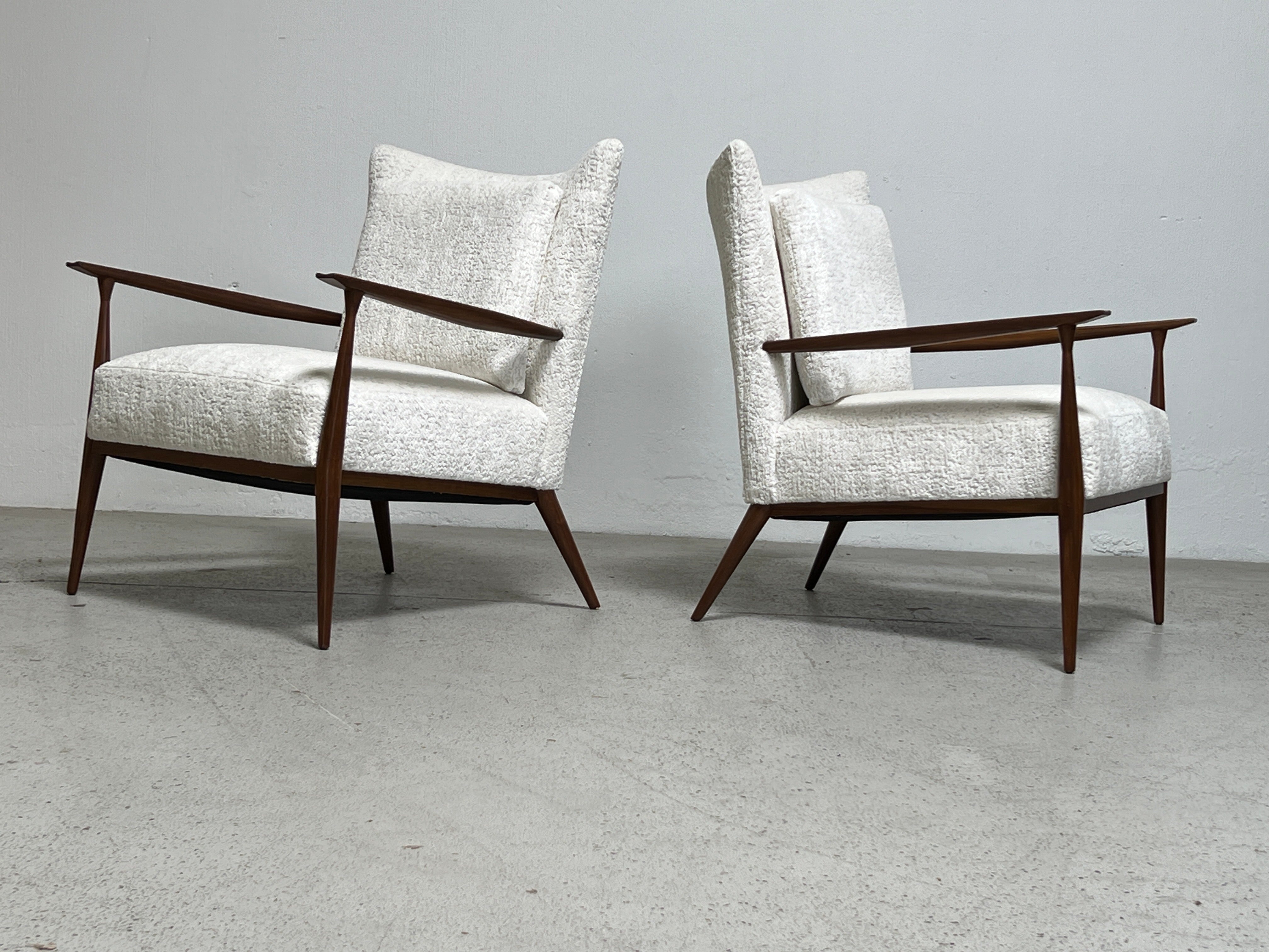 A pair of walnut lounge chairs designed by Paul McCobb. Fully restored and upholstered in Holly Hunt / Plushy / Soft Light.