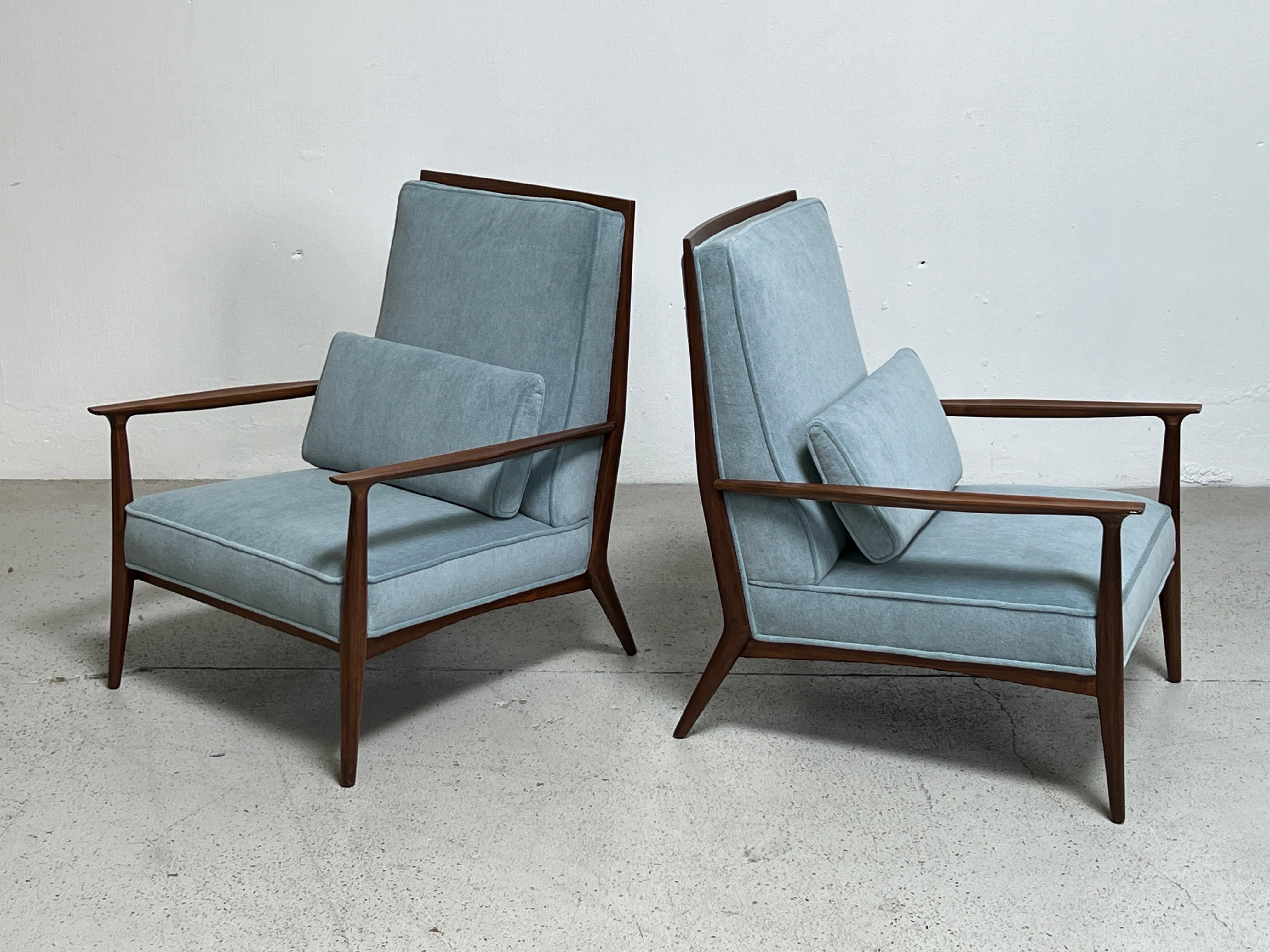 A pair of walnut lounge chairs designed by Paul McCobb. Fully restored and reupholstered in Holly Hunt / Alpaca Velvet / Serenity. 