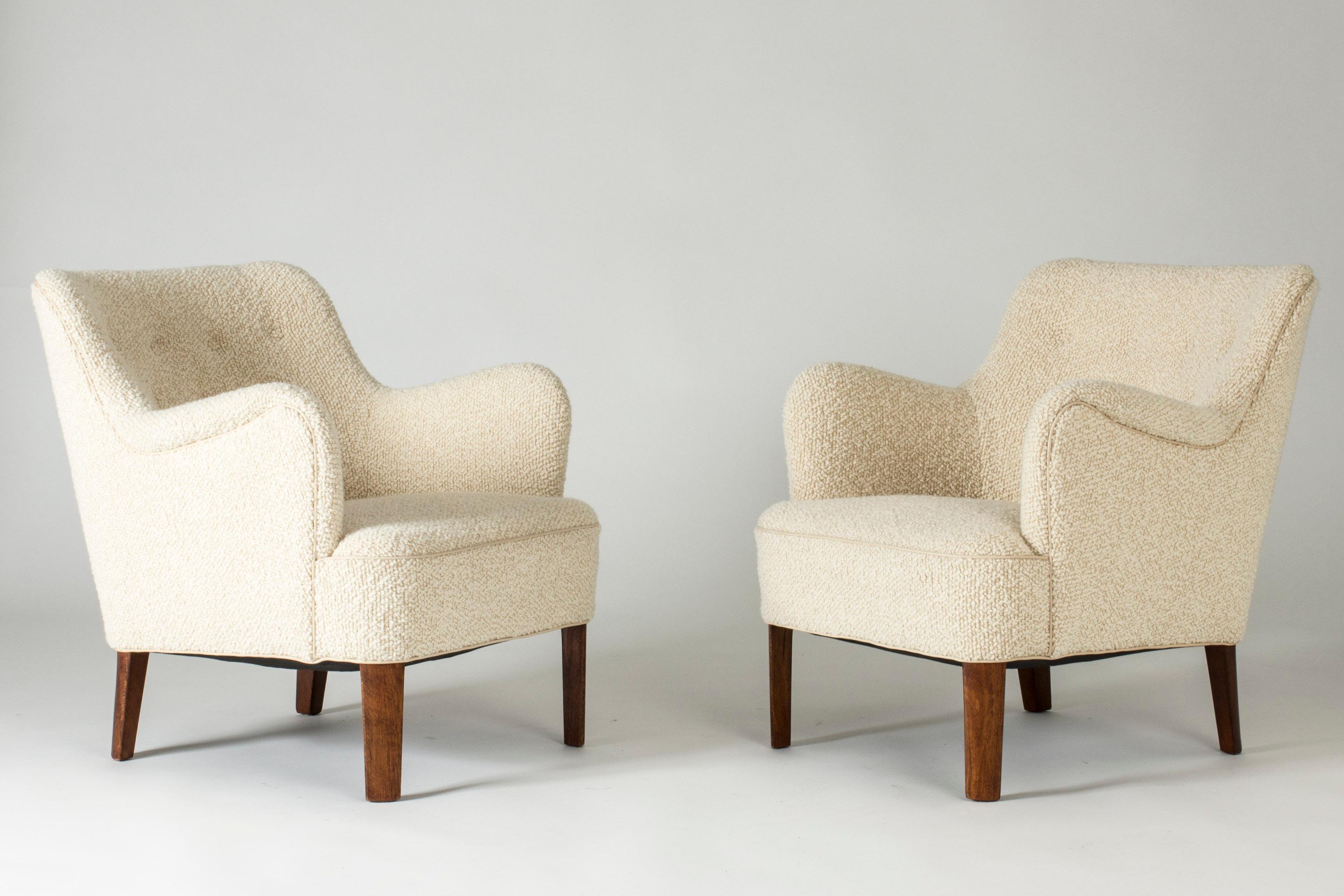 Pair of elegant lounge chairs by Peter Hvidt, in a neat size and with curved forms. Upholstered with quality bouclé fabric, white leather piping. Seat height 39 cm.