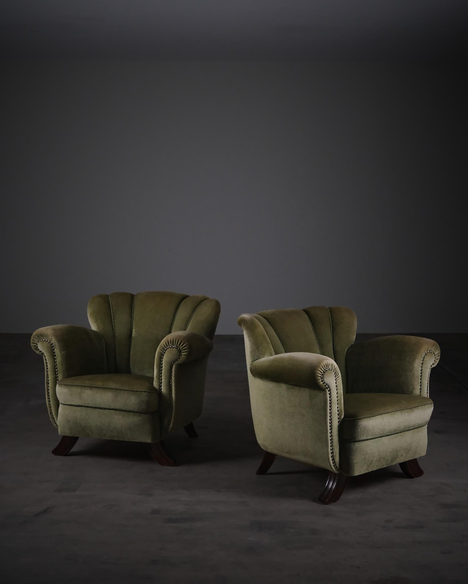 Une belle paire de fauteuils suédois des années 1940, fabriqués par un ébéniste inconnu. Les chaises se distinguent par leur dossier festonné et leurs pieds avant sculptés en hêtre teinté, qui s'évasent doucement vers l'extérieur - un détail subtil