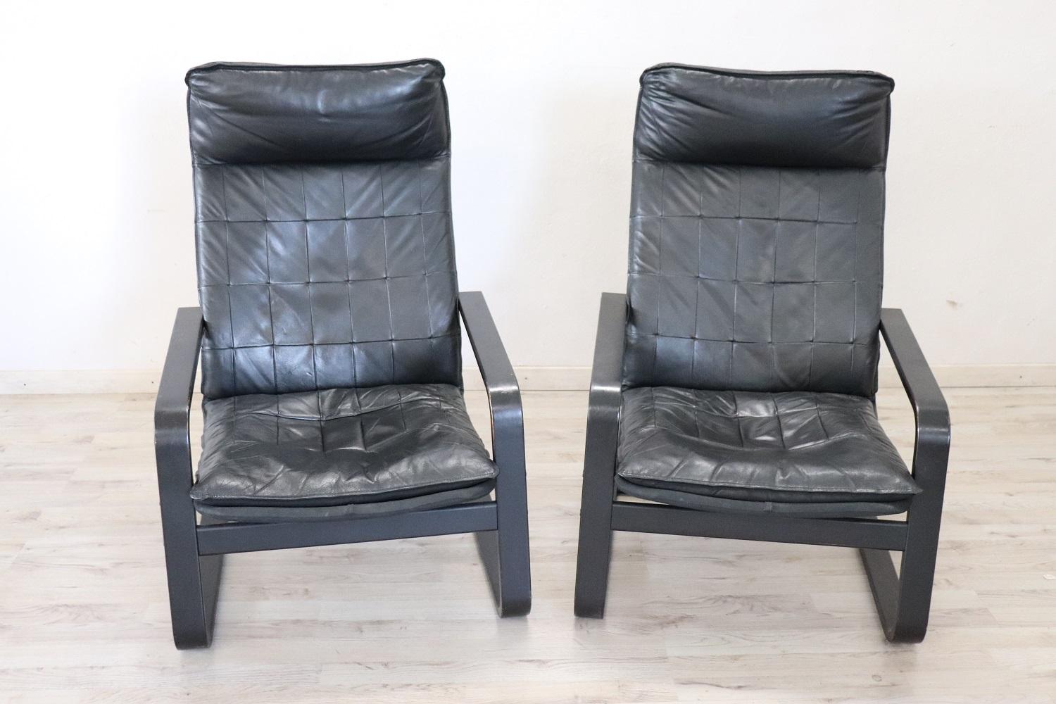 Paar Sessel italienisches Design 1970er Jahre, das Holz ist schwarz gefärbt, in schwarzem Leder bezogen. Schauen Sie sich alle Bilder, gibt es einige Anzeichen von Verschleiß.
