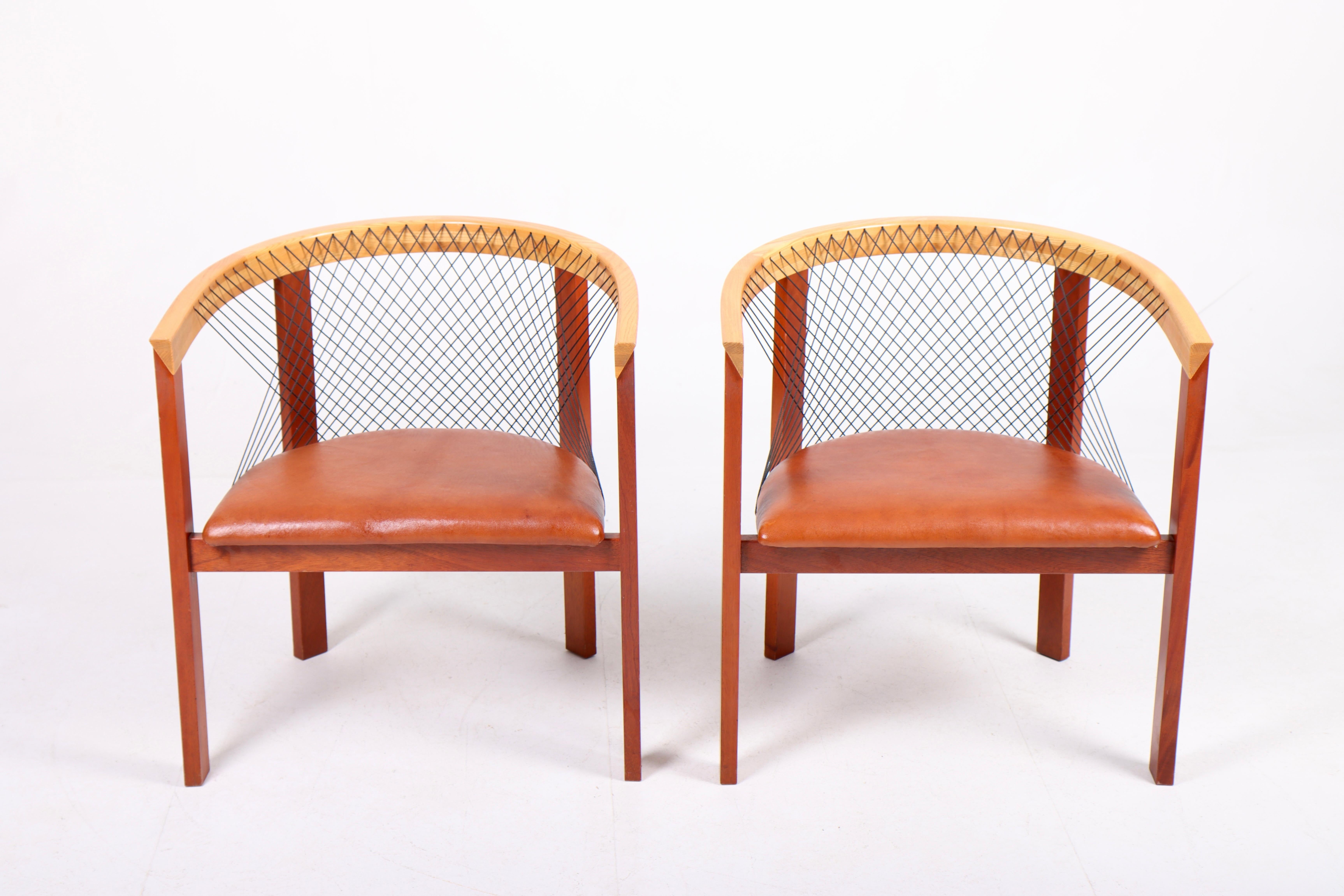 Pair of lounge chairs in a rare combination of elm and mahogni. Designed by Danish architect Niels Jørgen Haugesen.