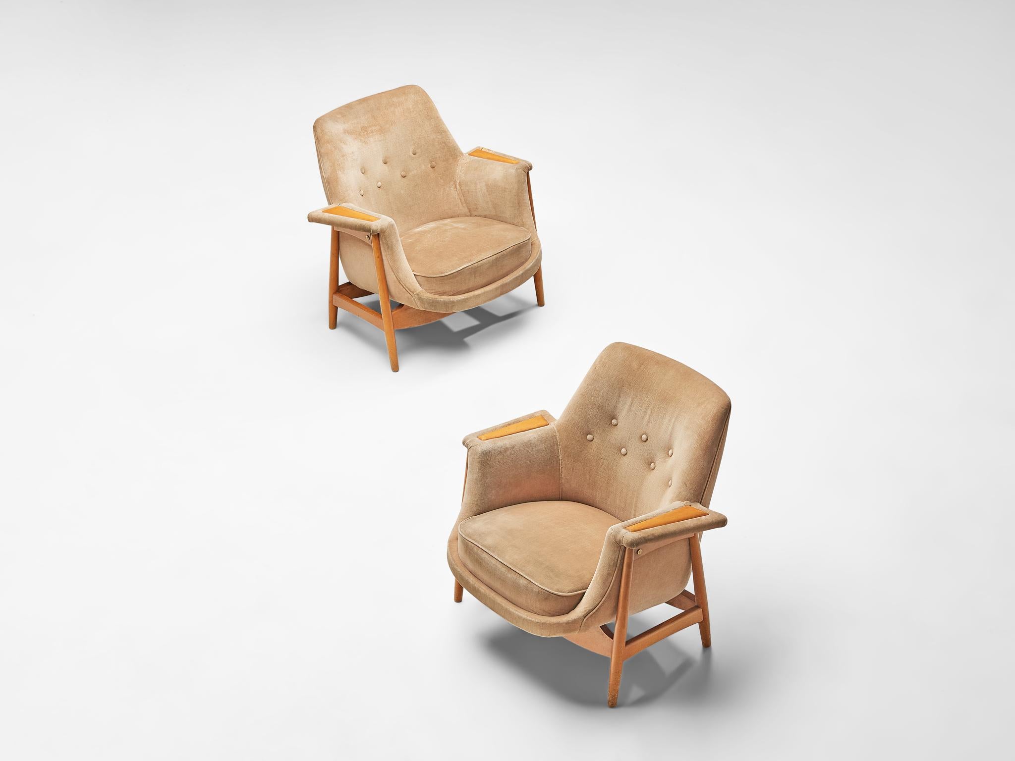 Pair of lounge chairs, oak and fabric upholstery, Europe, 1970s.

This elegant pair of lounge chairs feature an oakwood frame where the seat is placed in. The seat is adorned with a tufted back, with a beautiful oak detail on the armrests.  The legs
