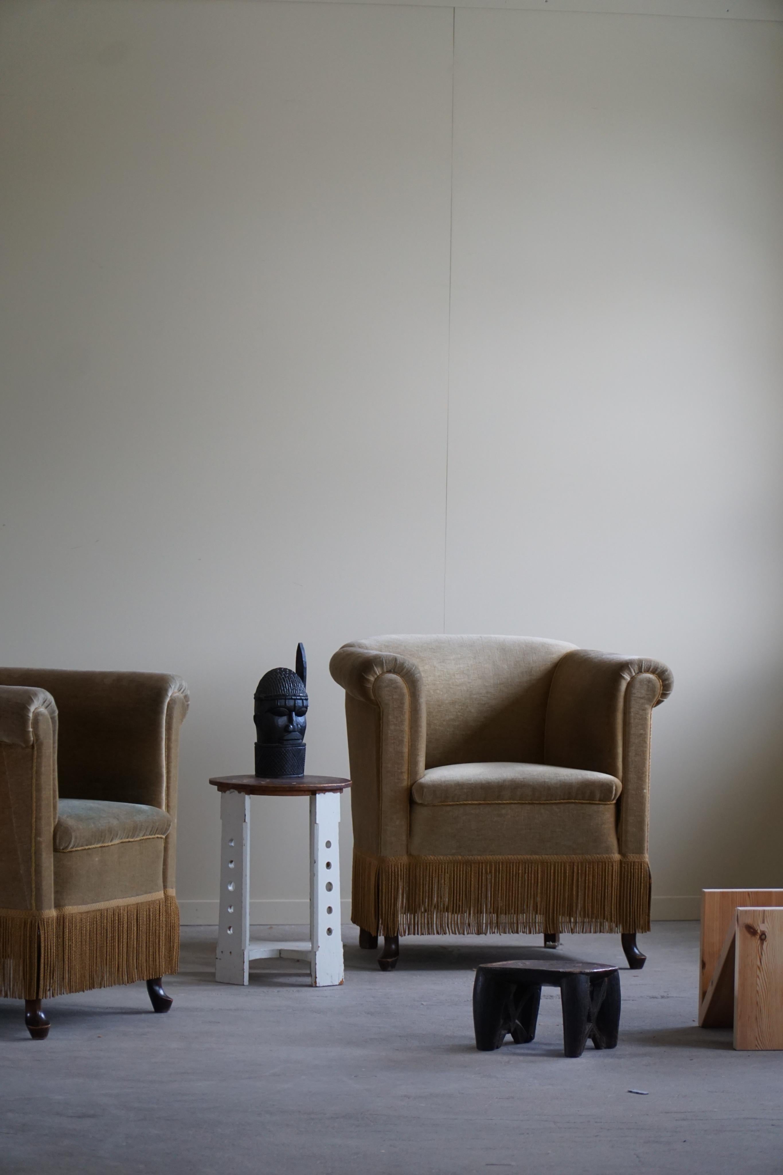 This pair of lounge chairs in green velour showcases the remarkable craftsmanship of a Danish cabinetmaker during the Art Deco period in the 1940s. These chairs exude an air of elegance and sophistication, combining the luxurious appeal of velour