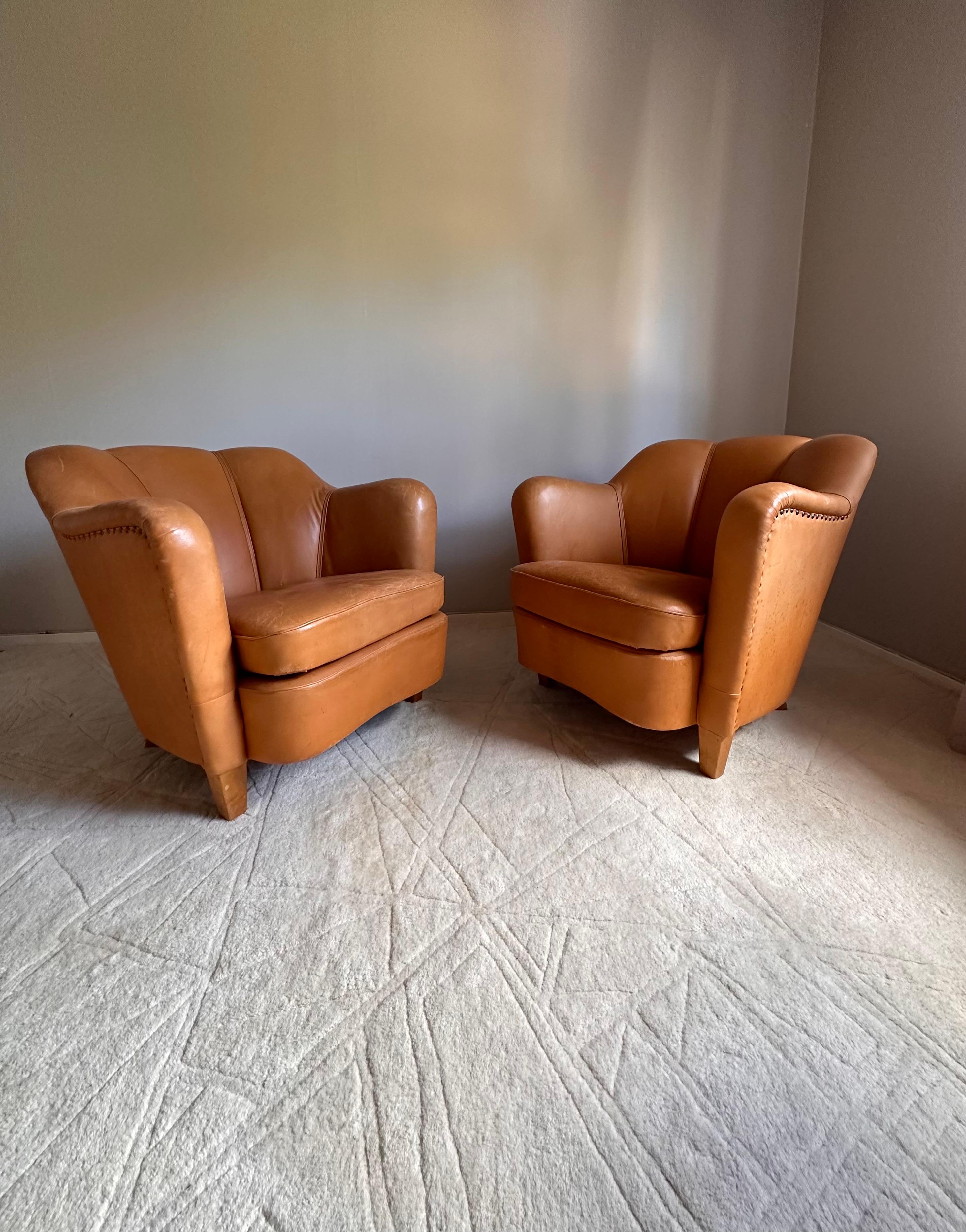 Pair of easy chairs in brown/cognac leather with beautiful patina.
Probably designed by Otto Schulz for Boet in early mid-century.

Dimensions(cm):
Height: 71
Width: 76
Depth: 68
Seat height: 40

Condition:
Excellent condition with