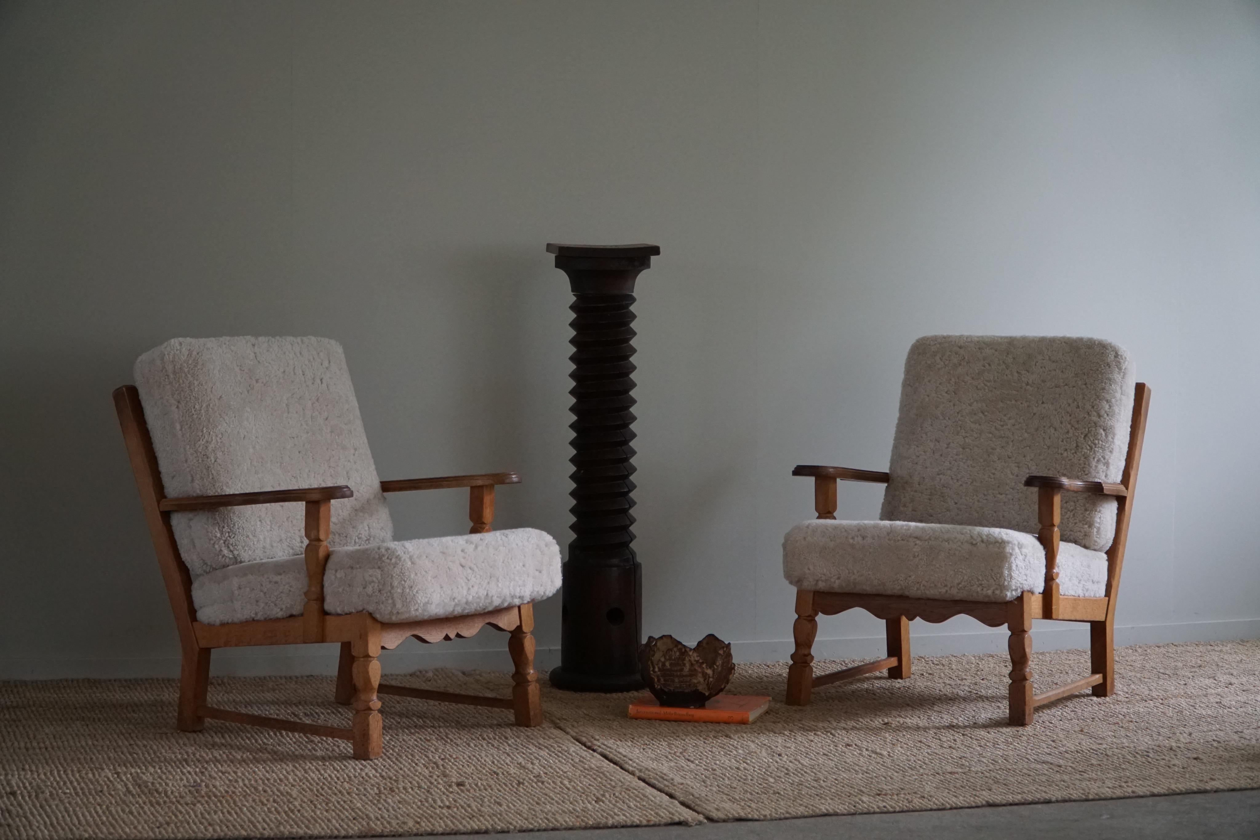 A stunning pair of Danish modern lounge chairs in the style of Henning Kjærnulf. Made in oak and reupholstered cushions in a great quality shearling lambswool. Made in 1960s by a Danish Cabinetmaker. The general impression is really good.

This nice