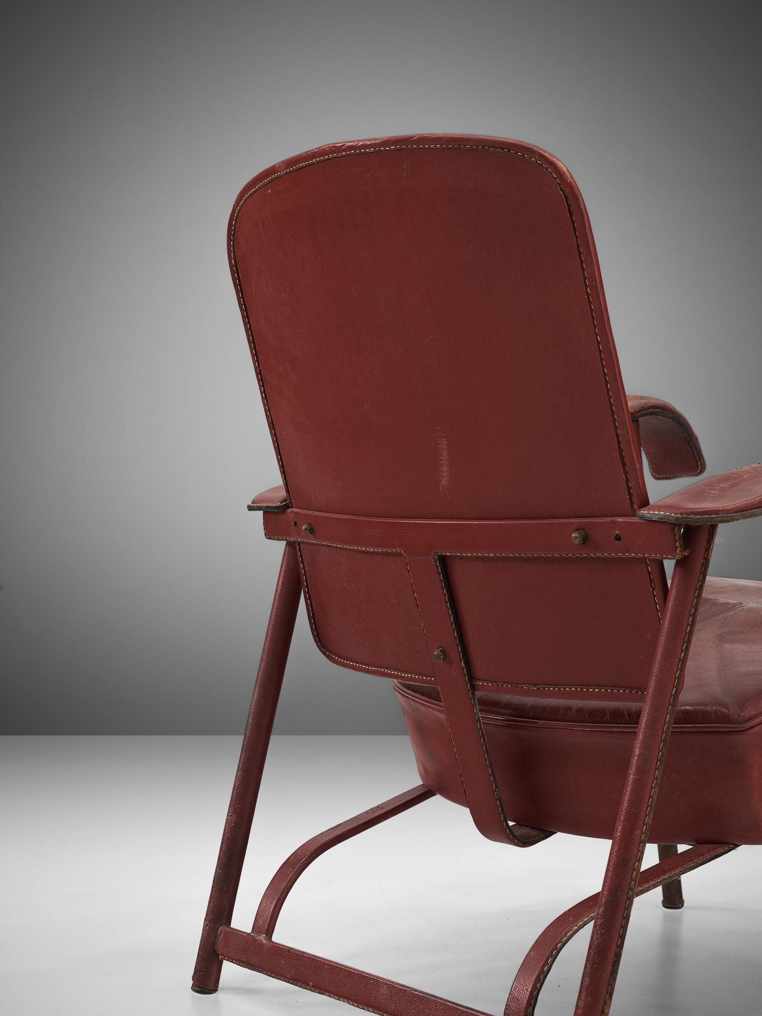 Mid-20th Century Pair of Lounge Chairs in Patinated Burgundy Leather by Jacques Adnet