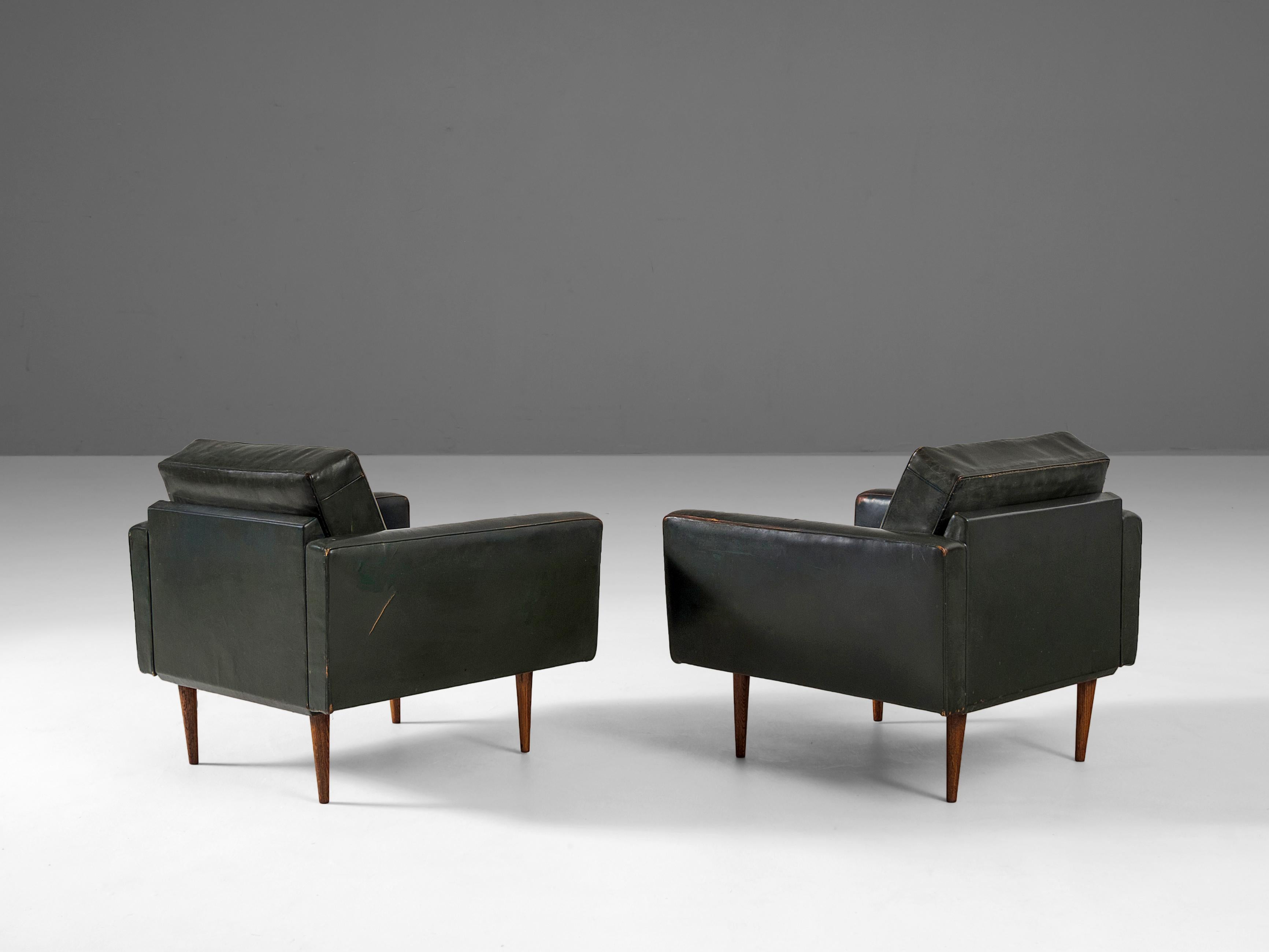 Armchairs, in leather and wood, Italian, 1960s. 

Pair of lounge chairs in leather. The leather upholstery of these easy chairs shows a beautiful patina, especially on the armrests, which gives these chair a vibrant appearance. Due the tapered,