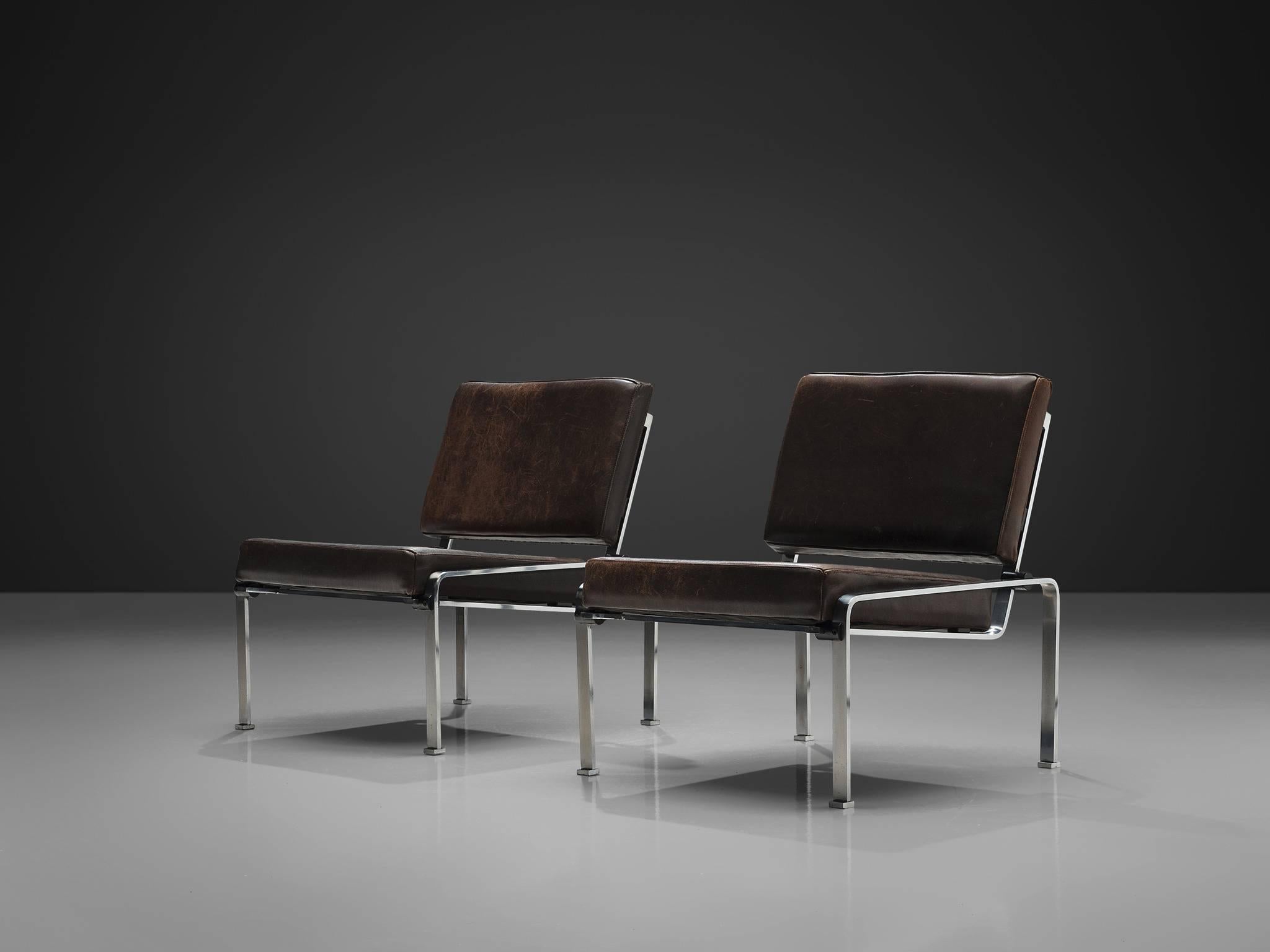 Pair of lounge chairs, in steel and black brown leather

Modern chairs in steel and patinated black brown leather. The transparant frame holds an L-shaped seating. The base of these chairs gives it it's characteristic and open character. The