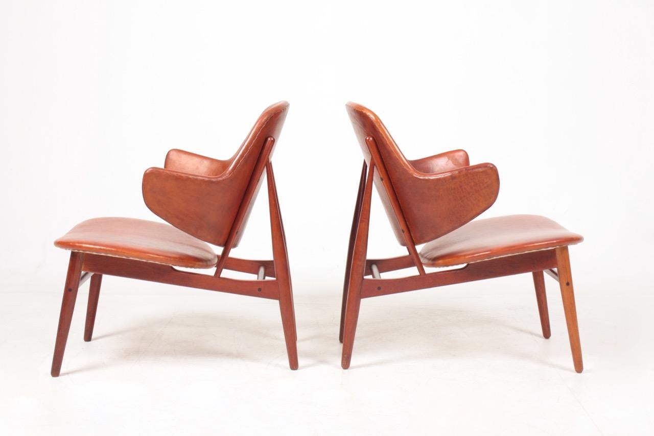 Pair of lounge chairs in leather and teak, designed by Maa. Ib Kofod Larsen and made by Christensen & Larsen Cabinetmakers. Great condition.