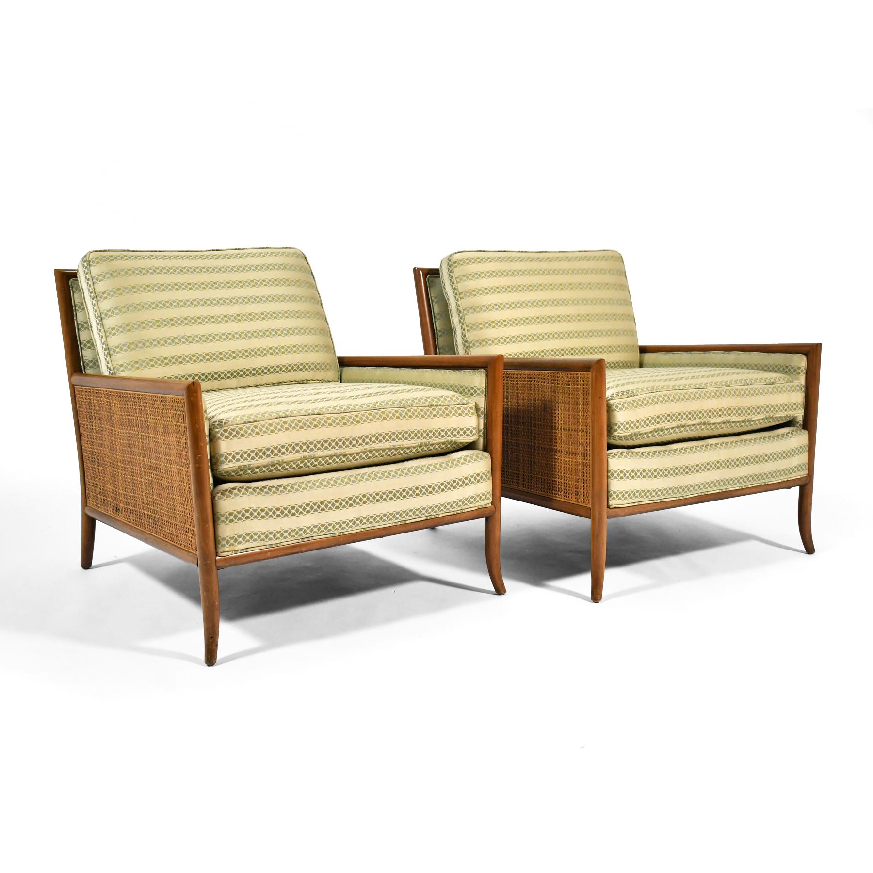 This handsome pair of lounge chairs share many characteristics with the designs of T.H. Robsjohn-Gibbings. Frames of bleached mahogany have tapered and subtly curved legs and cane inset into the sides enveloping the upholstered interior.

28