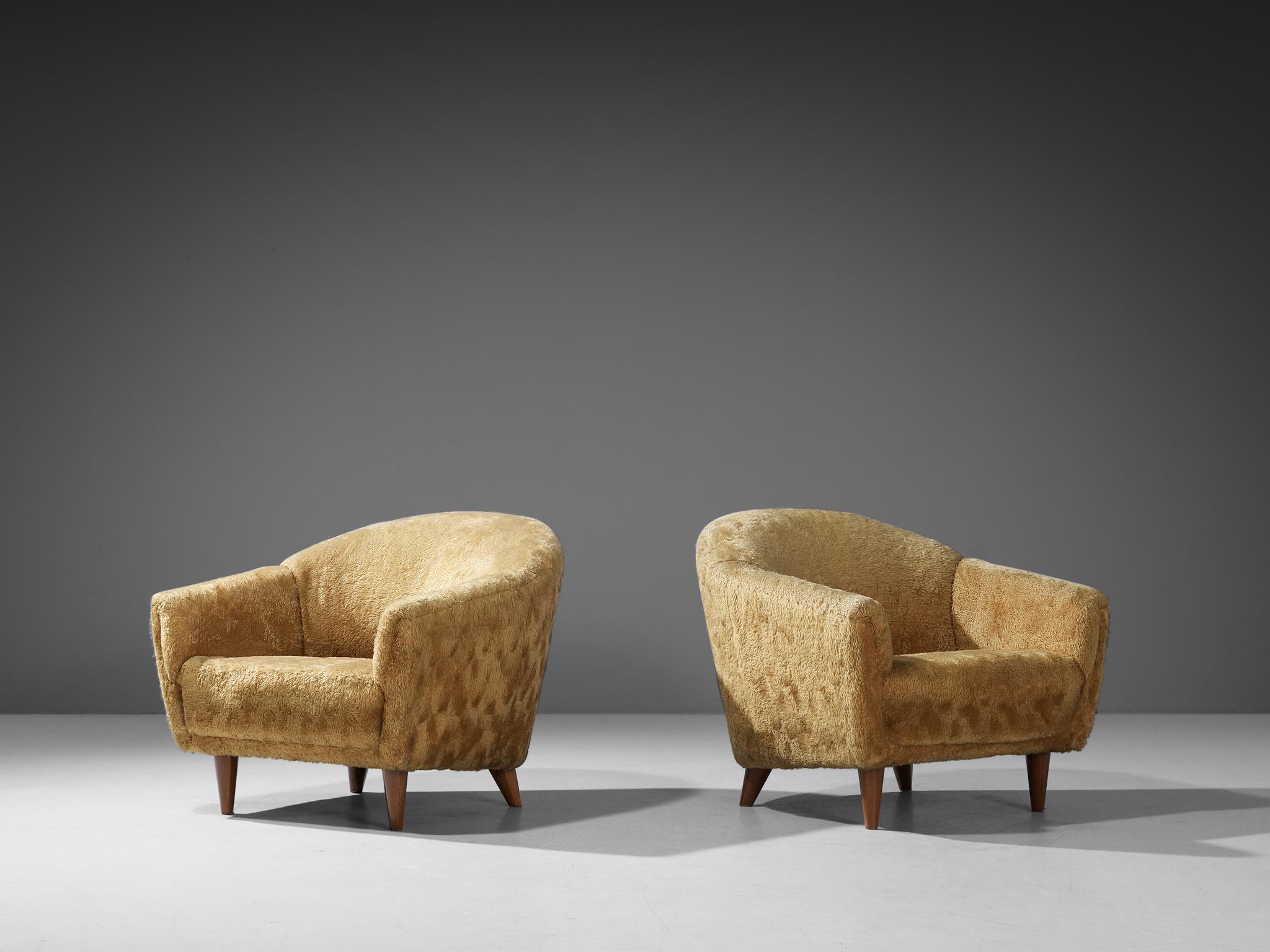 Lounge chairs, teddy upholstery and beech, Europe, 1950s

This pair of bulky lounge chairs are furnished with wooden legs and a yellow teddy upholstery. The lounge chairs have a high lined and slightly curved back, while the backrest is horizontal