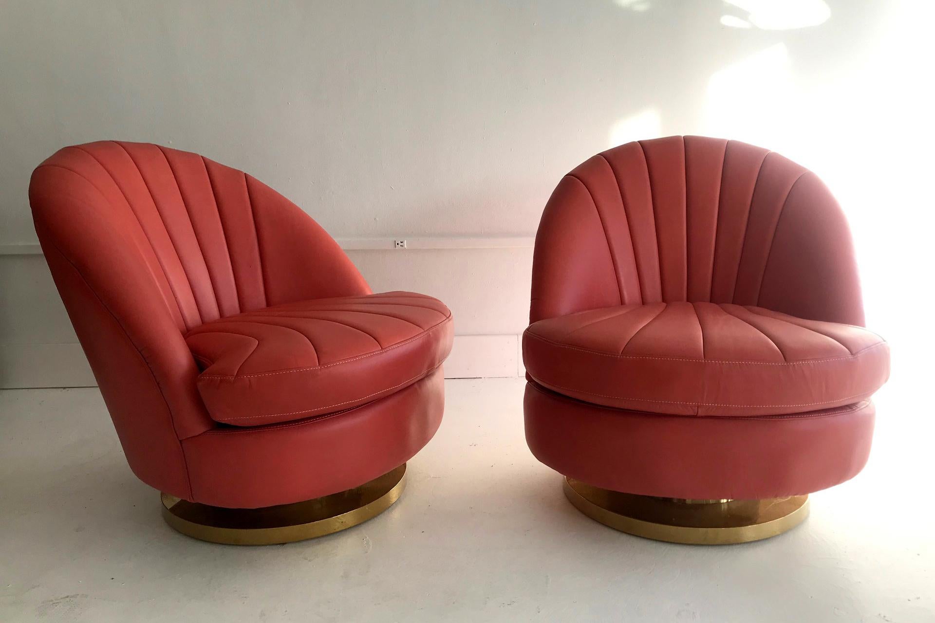 A pair of lounge chairs on brass base. Upholstered with channeled leather in an eye-catching peach color. They are likely designed by Milo Baughman, circa 1970s, with a nod to the glamor of Hollywood Regency.

 