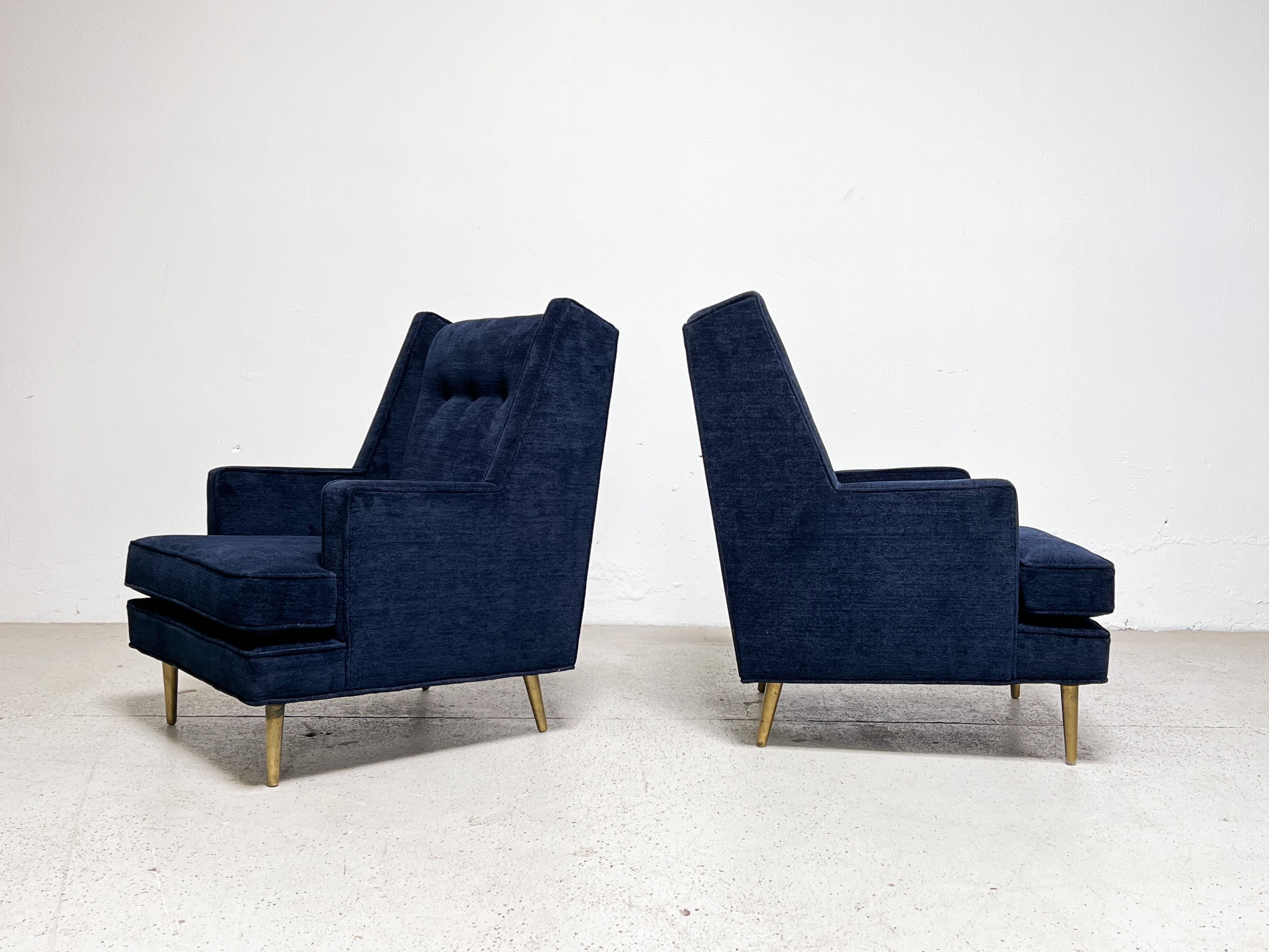 A classic pair of Dunbar high back lounge chair on brass legs designed by Edward Wormley. Fully restored and upholstered in a deep blue chenille fabric.