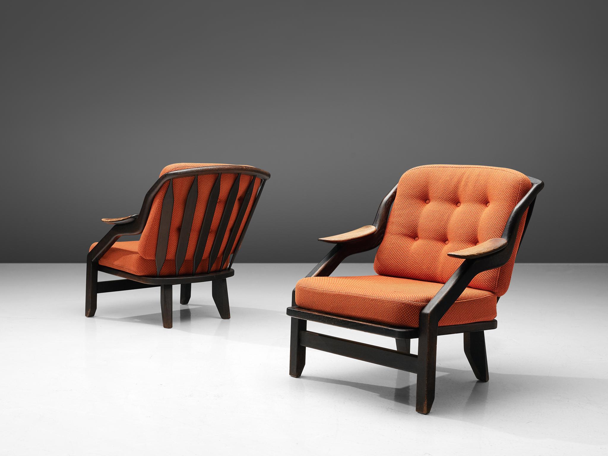 Guillerme & Chambron, pair of lounge chairs, orange fabric and dark stained oak, France, 1950s.

A pair of lounge chairs by Guillerme et Chambron, this French designer duo is known for their extreme high quality solid oak furniture, from which this