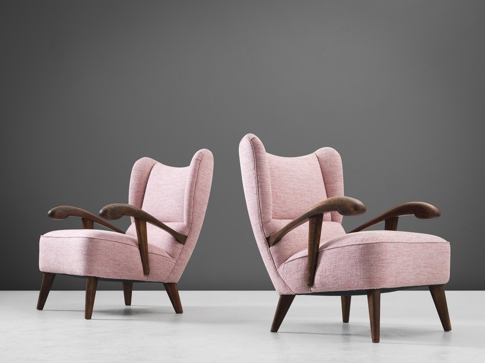 Pair of lounge chairs, stained beech, fabric, Czech Republic, 1950s. 

This beautifully designed lounge chair holds a striking construction by means of the sculpted elements discernible in the wooden frame and back. The armrests are characterized by