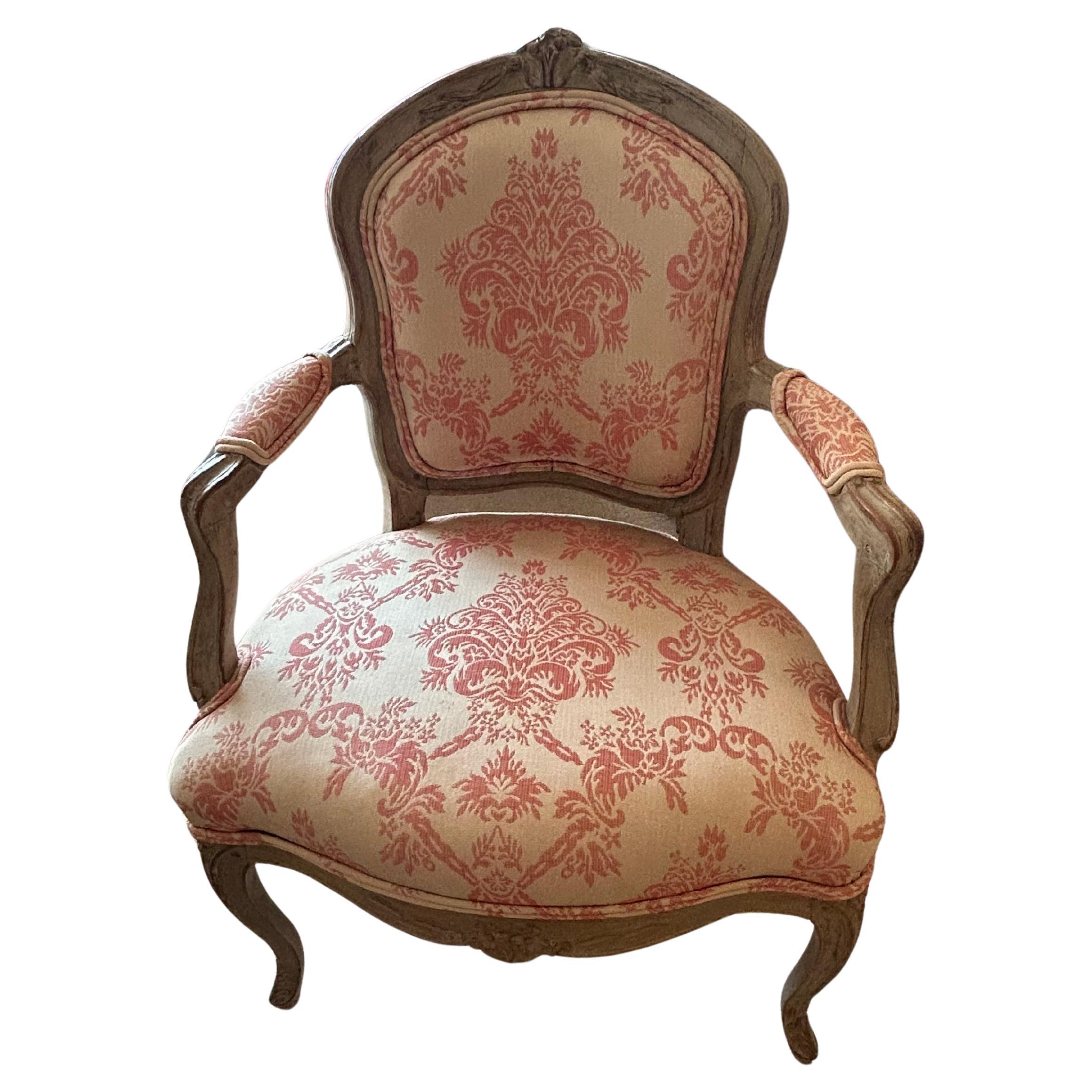 Magical pair of diminutive French antique bergeres having marvelous celadon colored frames and cream and raspberry upholstery finished with nailheads.  