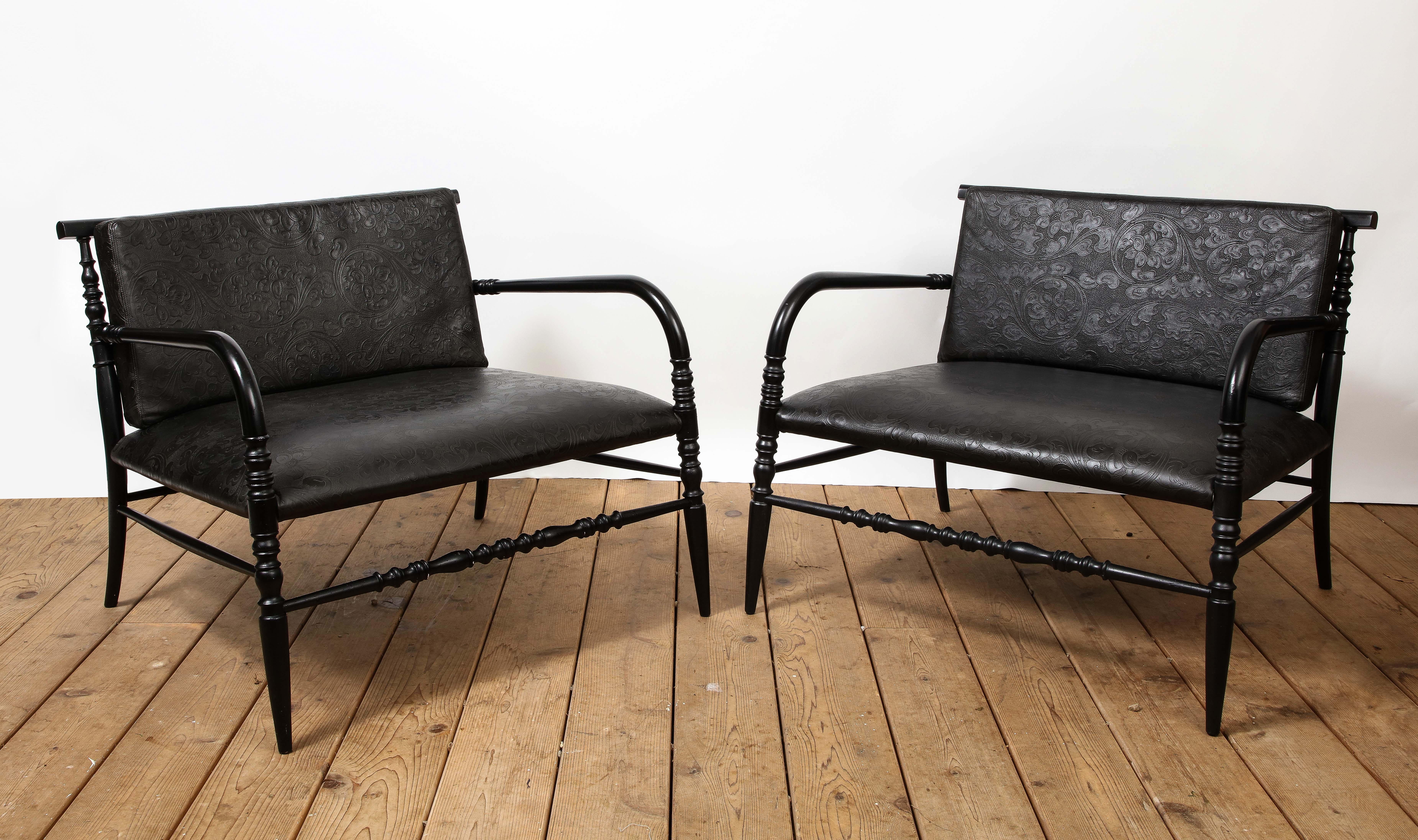Pair of 20th century American low-slung lounge chairs with embossed black leather seats and backs on turned wood frames. 

Additional dimensions: 
AH 21