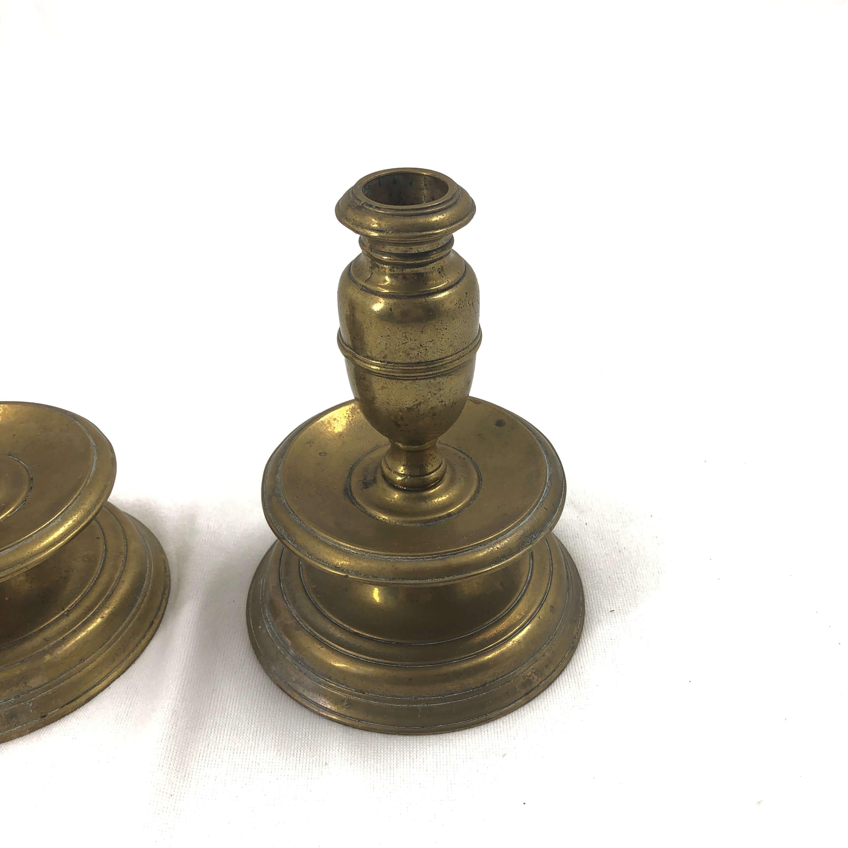 An early pair of brass capstan candlesticks with mid drip.
 