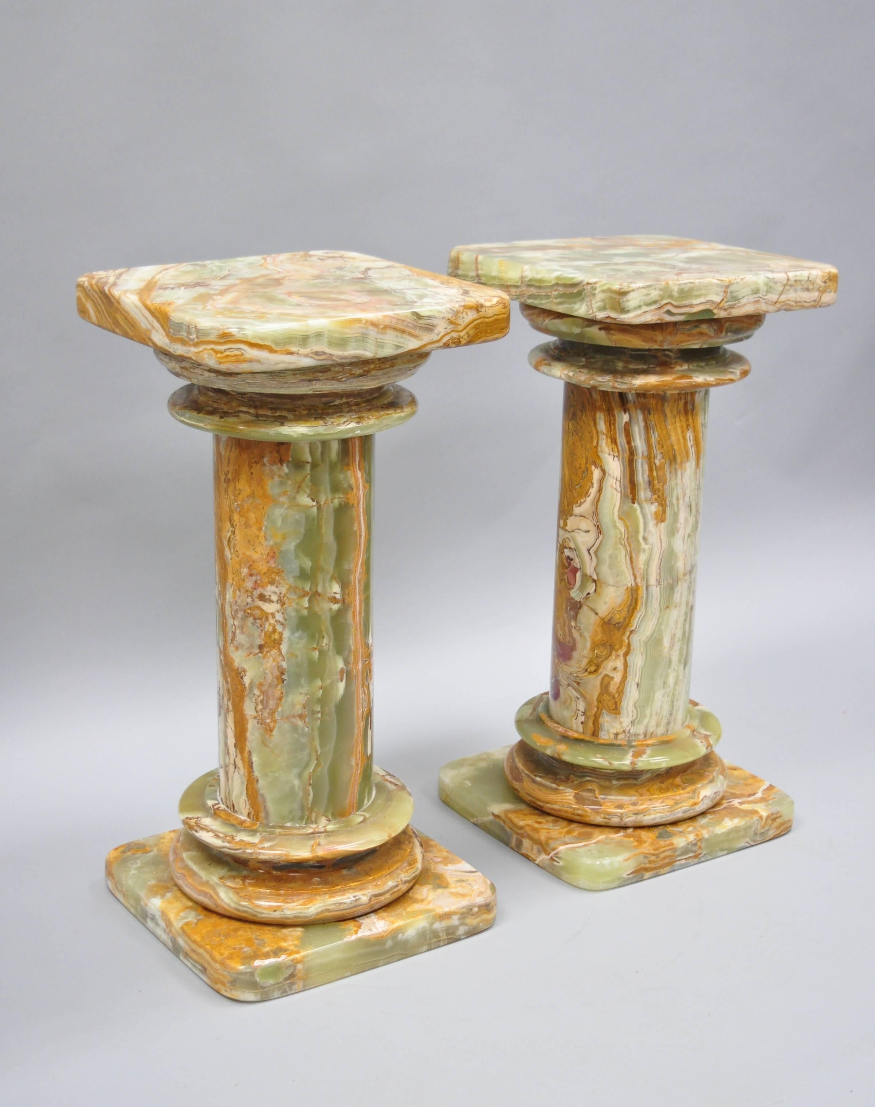 Pair of low green onyx stone classical column pedestals. Item features beautiful green and brown onyx stone, rounded central columns, square tops with rounded edges, three-part construction, great style and form, circa mid-late 20th century.