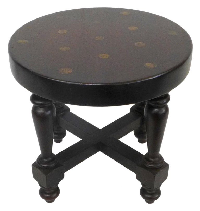 A handsome pair of low, turned wood round side tables or stools.  Turned wood legs with a thick round top adorned with inset Argentinian copper coins.  A deep walnut, approaching ebony stain throughout.  Great, alluring detail and unusual compact