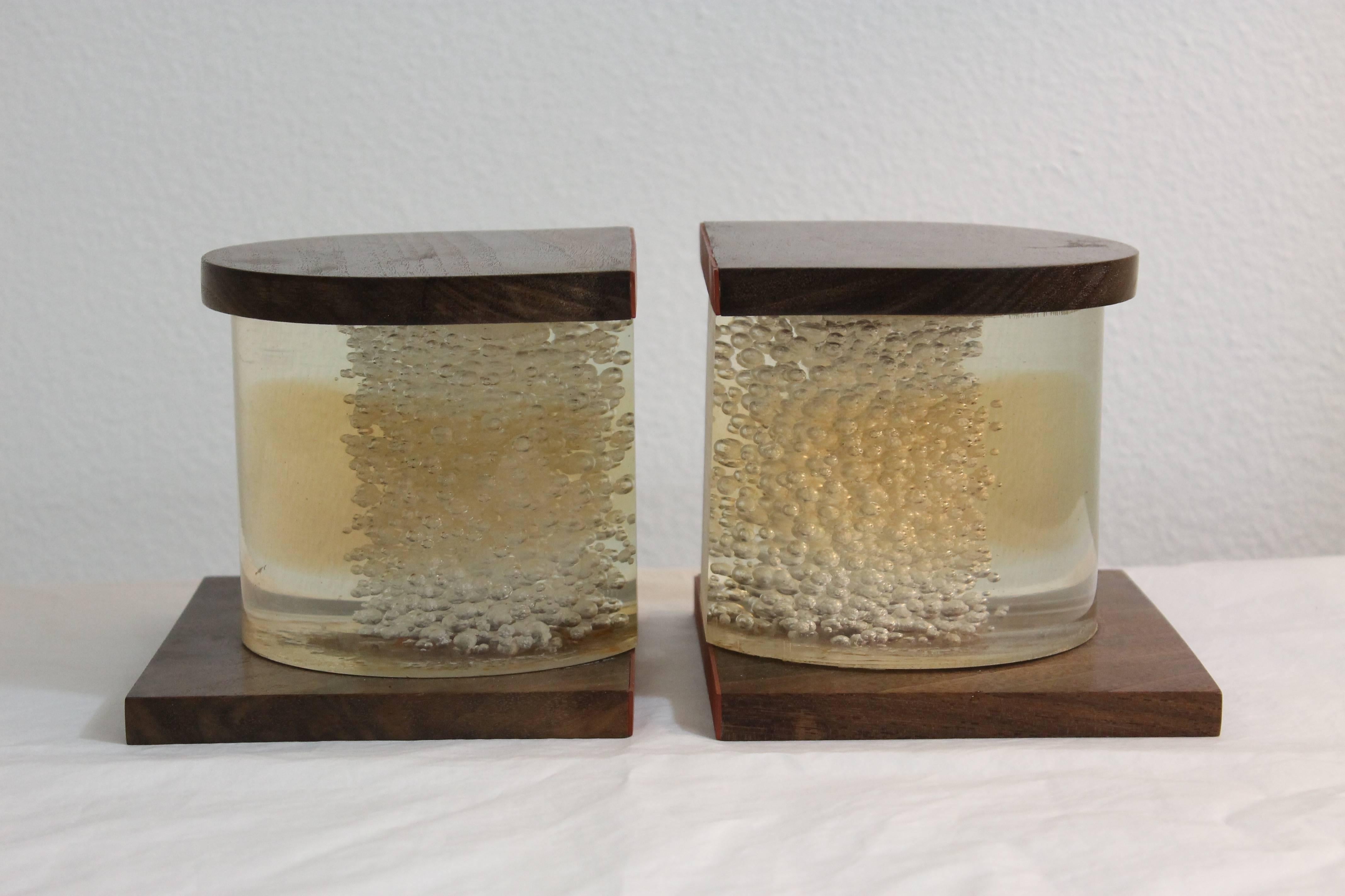Pair of Lucite and wood bookends. Lucite looks like it has suspended bubbles. They each measure 5.5