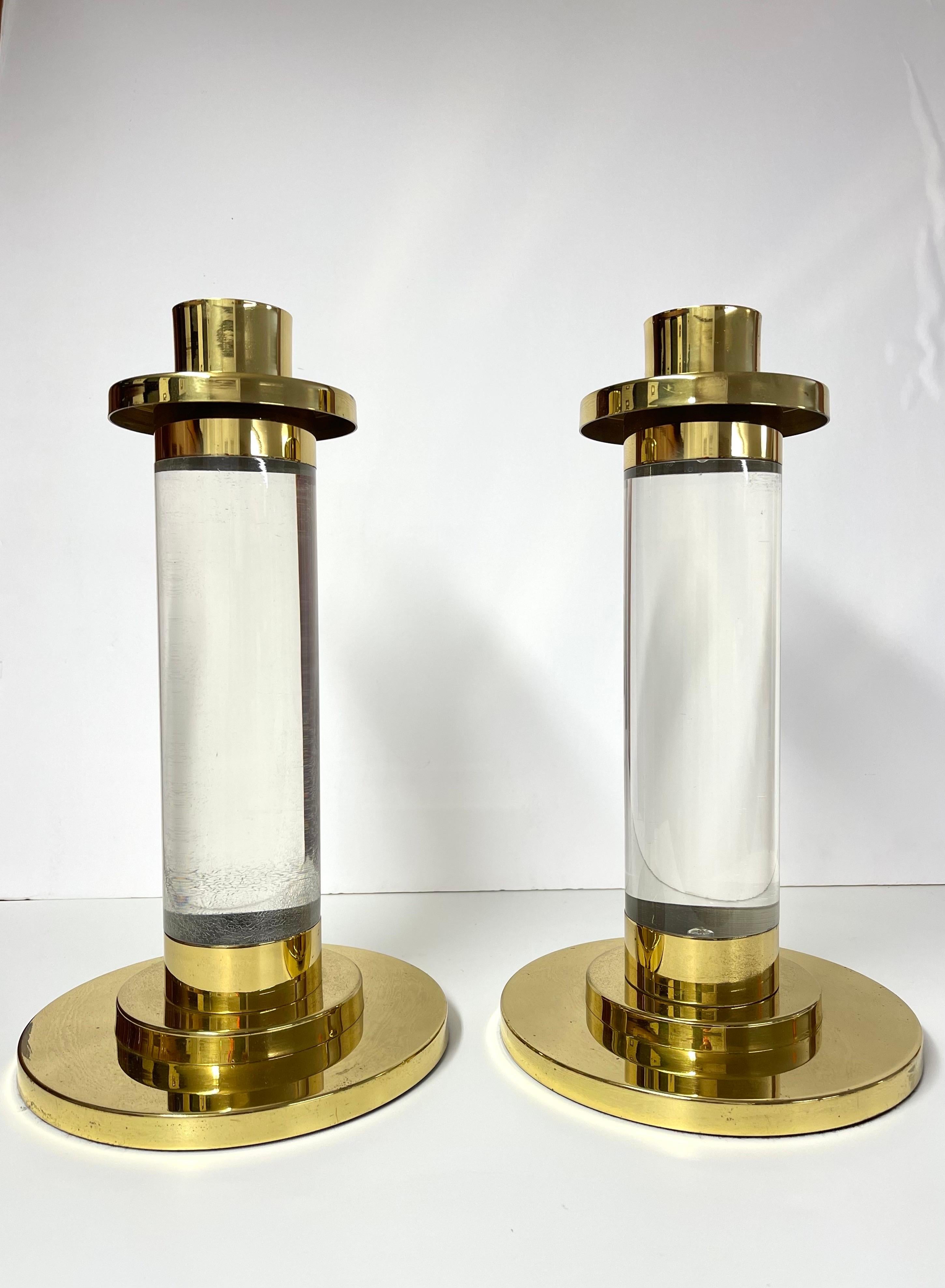 Pair of Lucite and Brass Column Candle Holders in the style of Karl Springer 
These are as Iconic as it gets. Classic and timeless pieces to accent any modern home.
