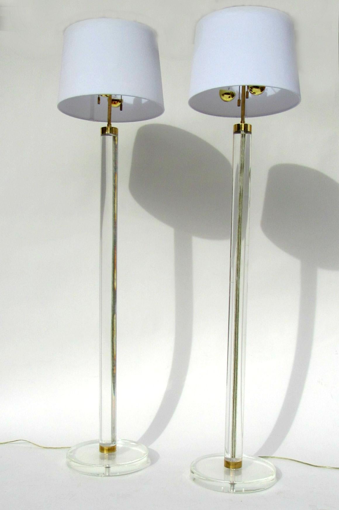 Karl Springer Lucite and Brass Floor Lamps, USA, 1970s.  Exquisitely crafted pair of brass and Lucite column floor lamps by Karl Springer, American, 1970s.  Heavy Lucite columns with brass hardware and incised channel for cord.  