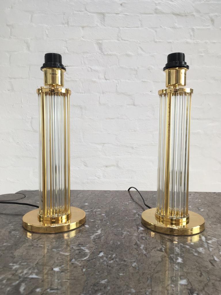 A pair of lucite and Brass plated lamps of European origin. Of medium size and perfect for a sideboard or for bedside use. They have a light and graceful appearance. 

Taupe Grey shades are new and included. Lamp without shade is 40 cm/15.75 inches